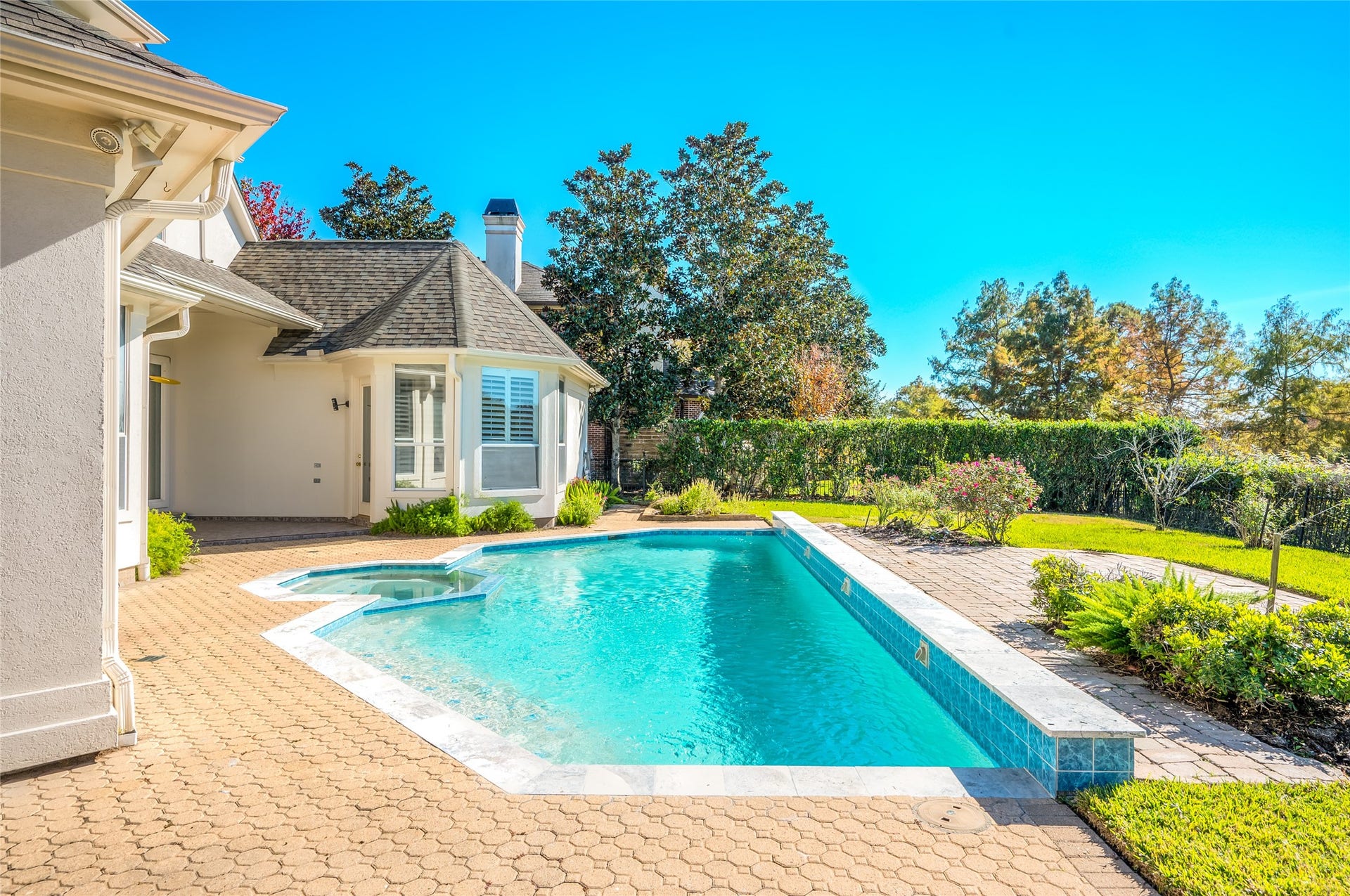 86 Pipers Walk, Sugar Land, TX 77479 Private backyard oasis with sparkling pool and relaxing waterfall feature.