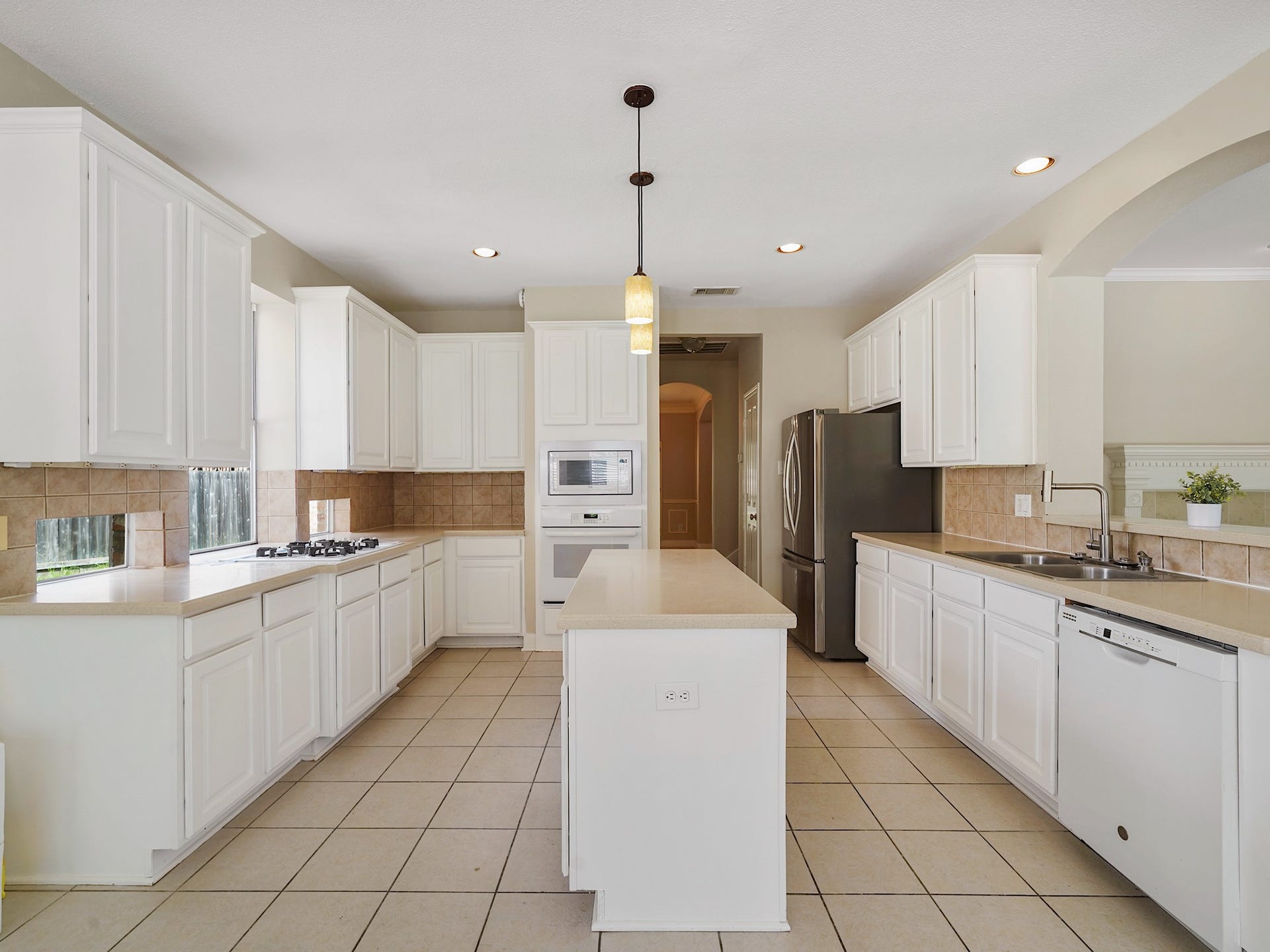 3907 Garnet Falls, Sugar Land, TX 77479 This spacious kitchen boasts white cabinetry, stainless steel appliances, and a central island.