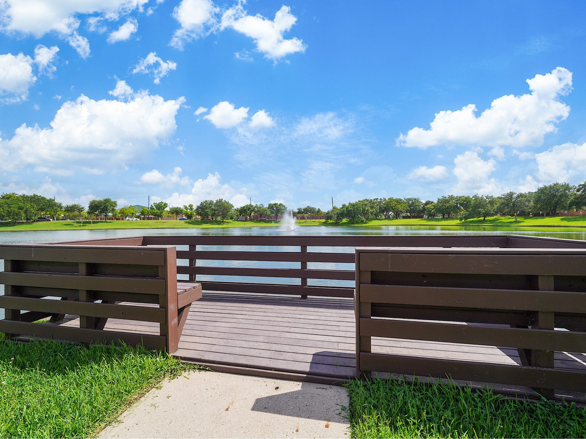 3907 Garnet Falls, Sugar Land, TX 77479 A pavilion area featuring picnic tables and a wooden deck overlooking the pond, ideal for relaxation and enjoying nature.