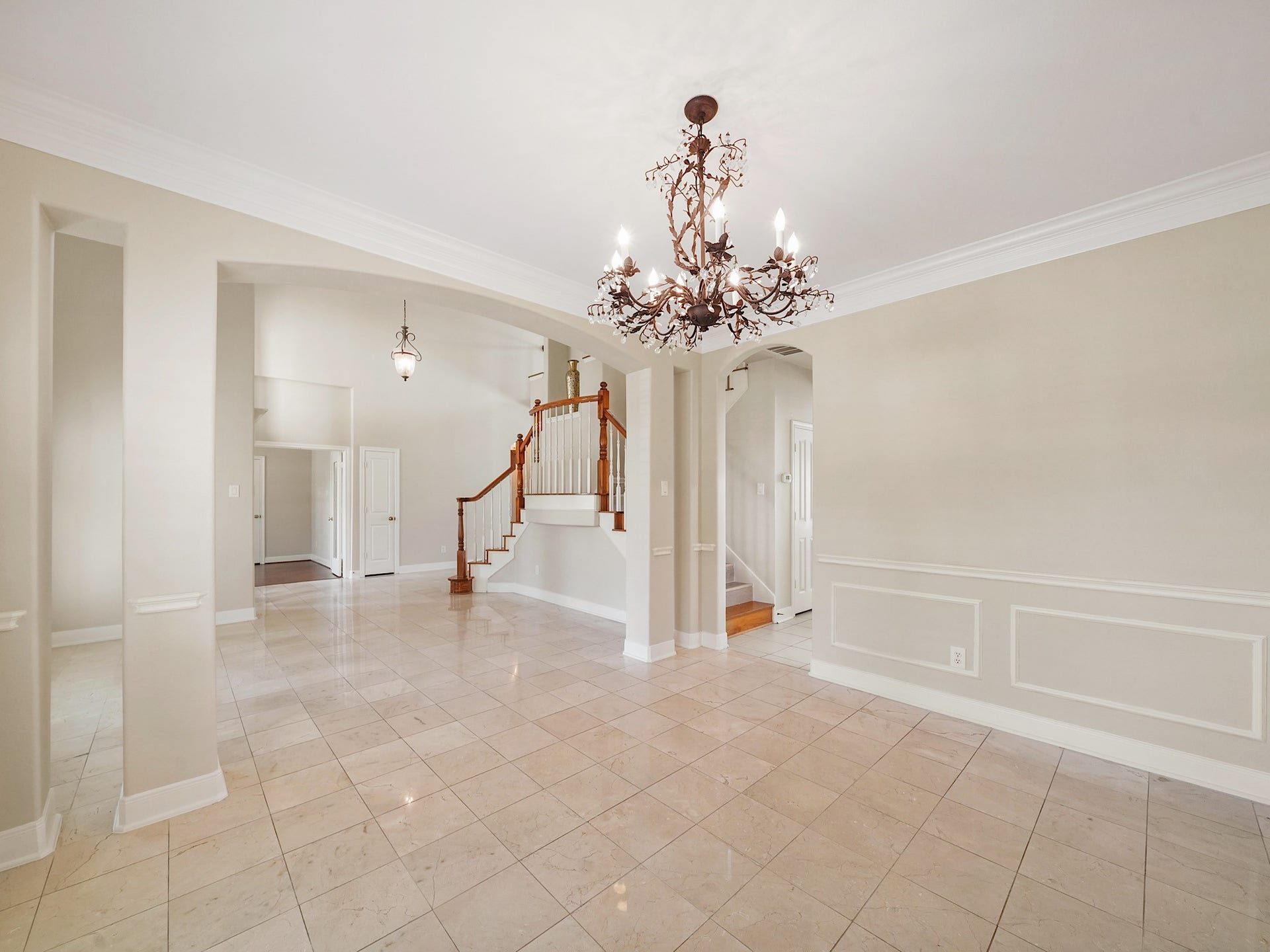 3907 Garnet Falls, Sugar Land, TX 77479 This dining area features large windows with plantation shutters, a chandelier, and tile floors. The space opens up to an inviting entryway with high ceilings.