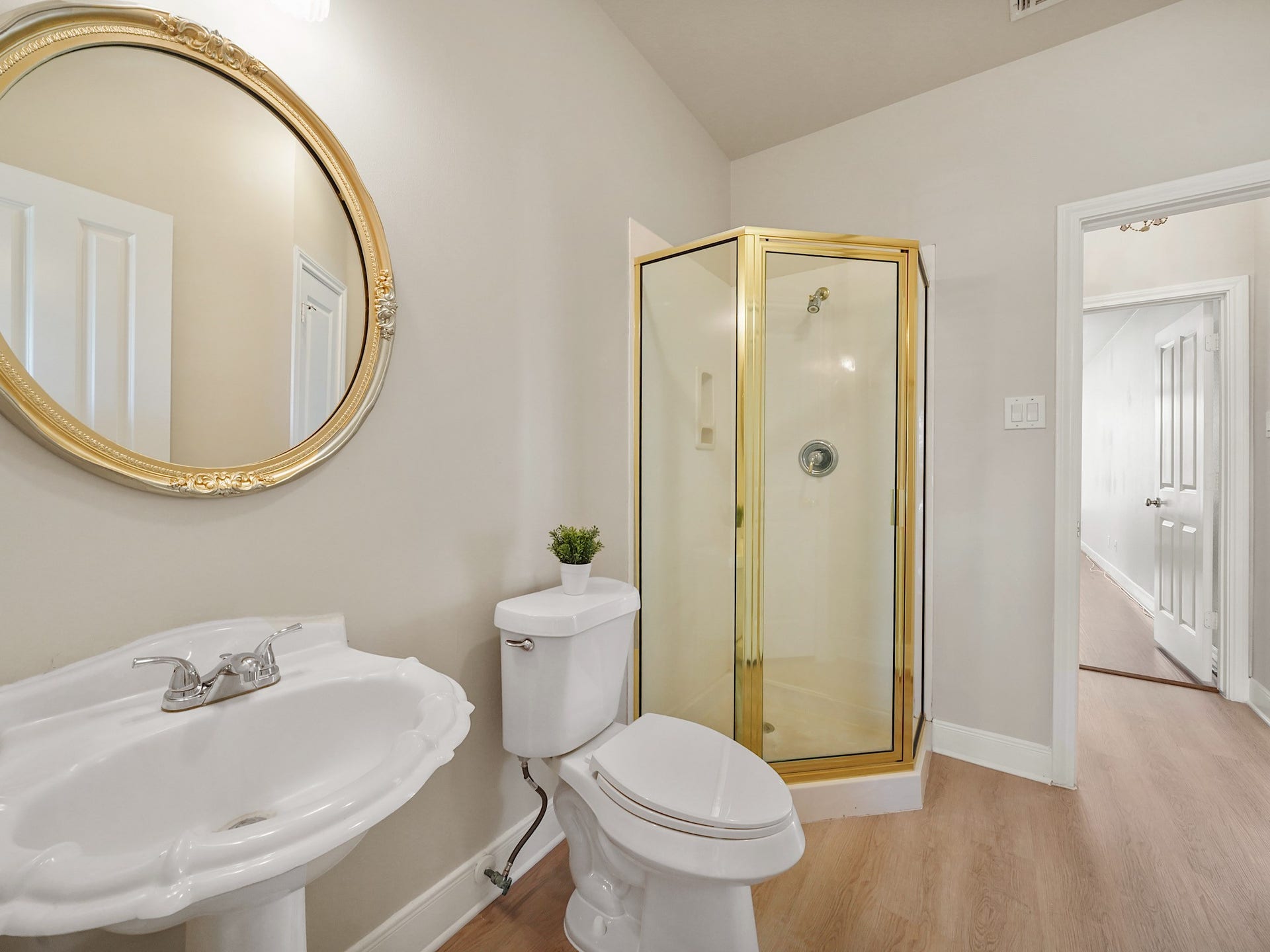 3907 Garnet Falls, Sugar Land, TX 77479 This bathroom features a corner shower, pedestal sink, and a round decorative mirror.