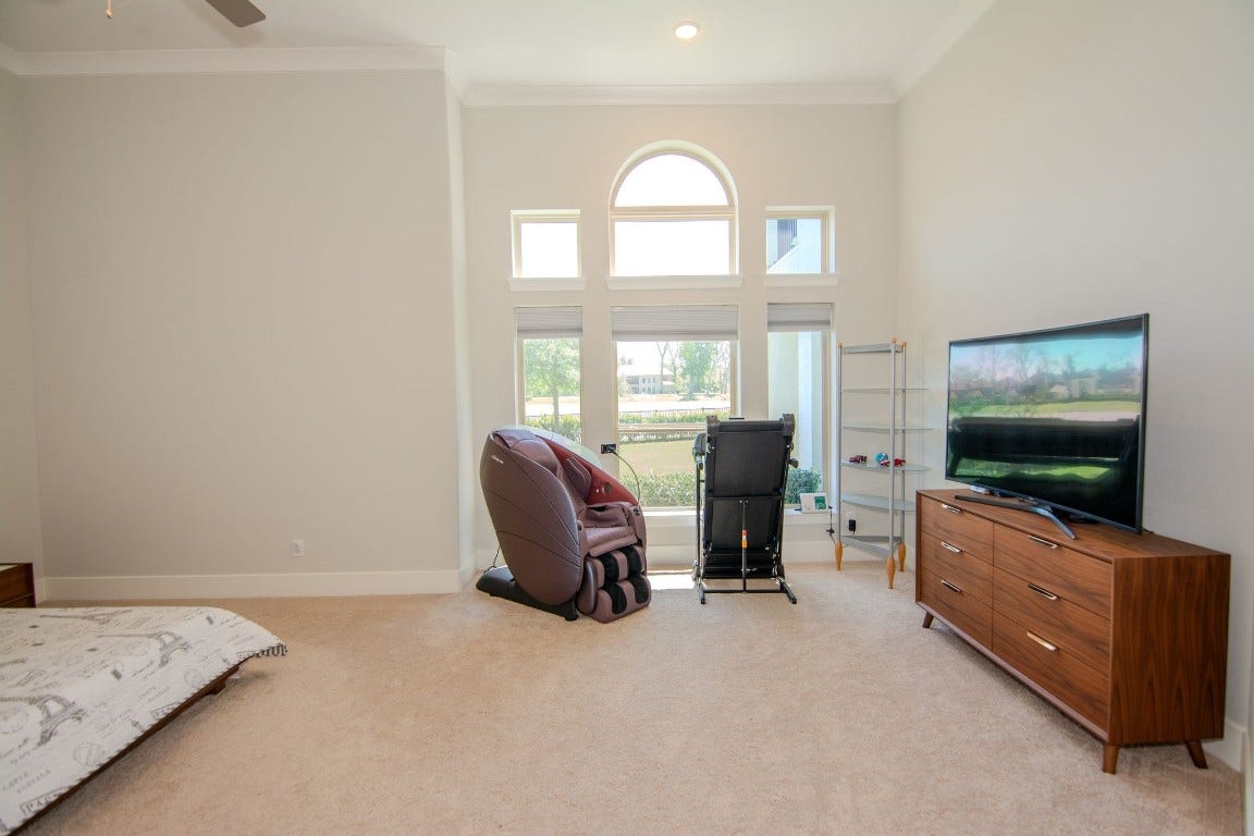 5423 Priamus Drive, Missouri City, TX 77459 This spacious primary room features high ceilings and abundant natural light from large windows.