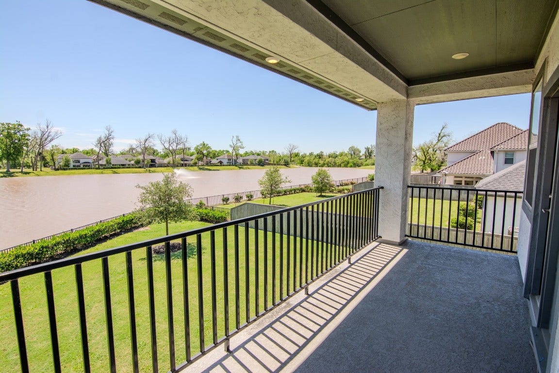 5423 Priamus Drive, Missouri City, TX 77459 Spacious balcony overlooking a serene lake and lush green landscape, perfect for relaxation and enjoying peaceful water views.