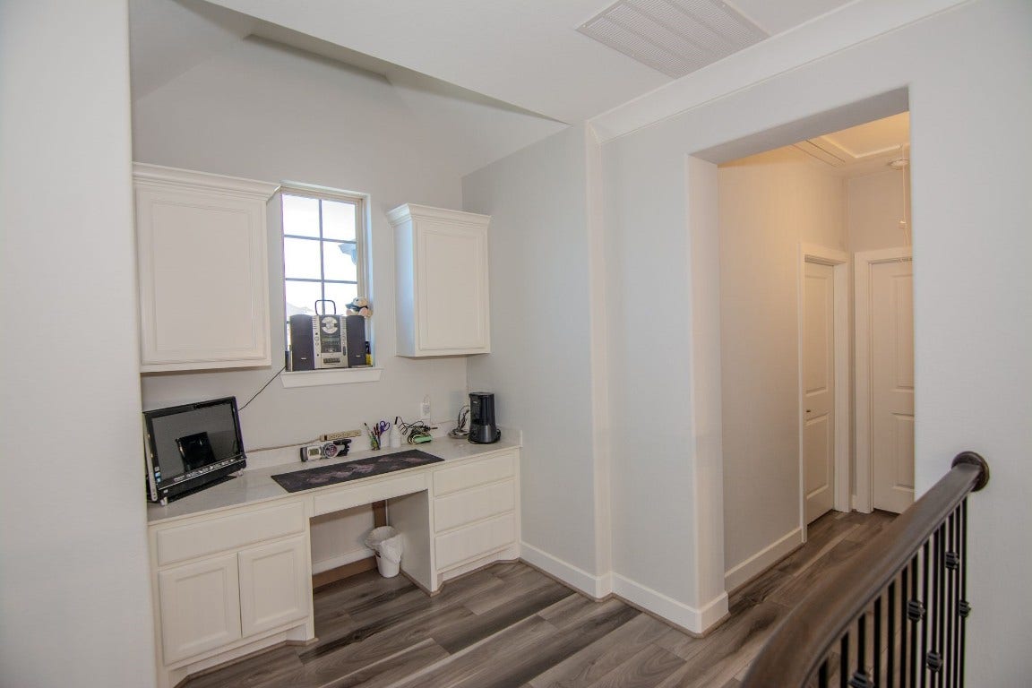 5423 Priamus Drive, Missouri City, TX 77459 Second-floor workspace with built-in desk and cabinetry.