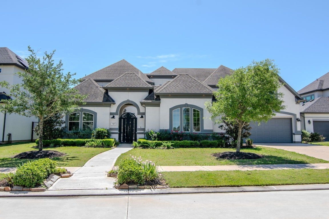 5423 Priamus Drive, Missouri City, TX 77459 This is a beautiful, spacious single-story home with a modern design, featuring a well-maintained lawn, a paved walkway, and a two-car garage. The exterior is accented with elegant windows and landscaped shrubs, enhancing its curb appeal.
