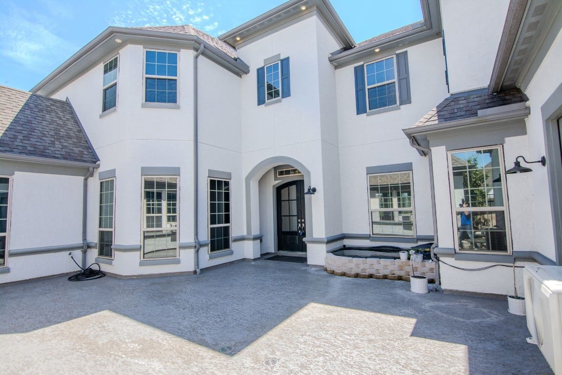 5423 Priamus Drive, Missouri City, TX 77459 This photo showcases a modern two-story home exterior with a spacious courtyard. The light-colored facade, large windows, and elegant entryway create a welcoming atmosphere. Ideal for those seeking a blend of style and functionality.