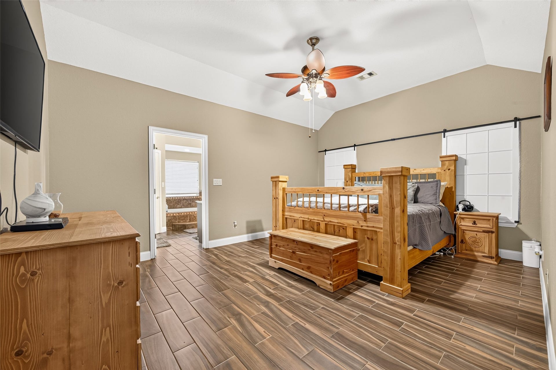 Relax and unwind in this spacious primary bedroom featuring high ceilings, beautiful wood-look flooring, and plenty of room for your favorite furnishings.