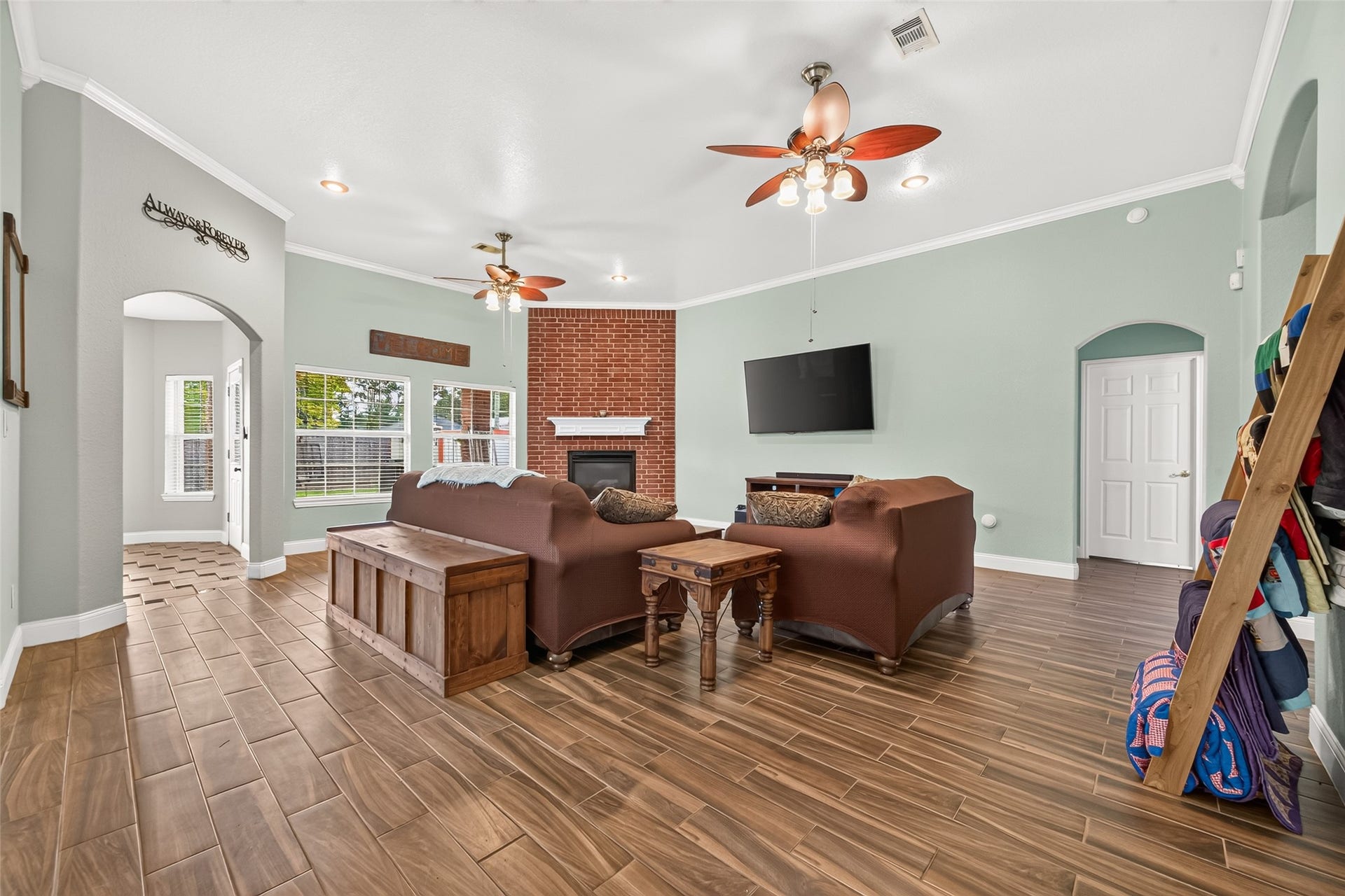 Another view of the spacious living room showcasing the high ceilings, abundant natural light, and easy flow into the adjoining areas.