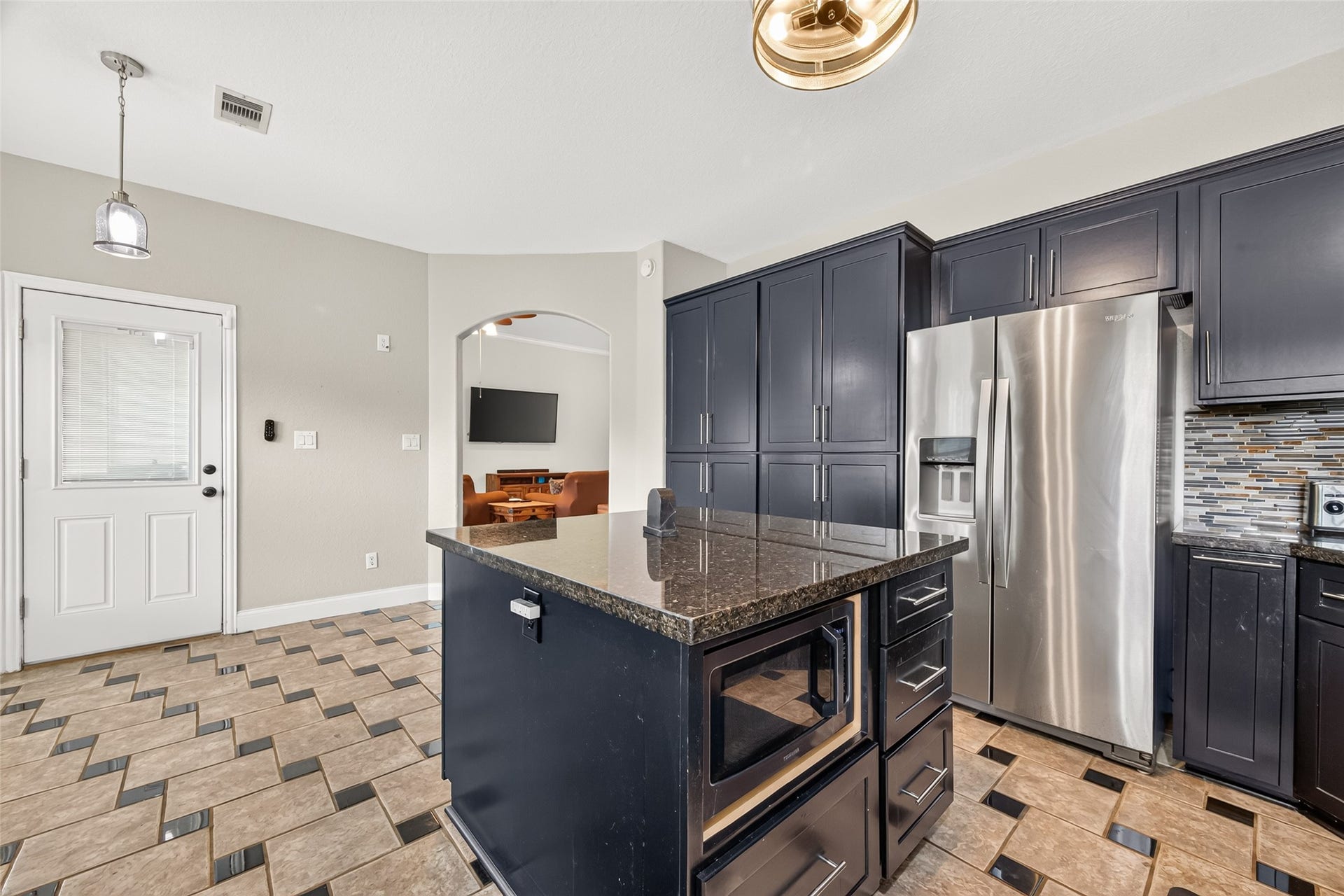 The center island provides additional prep space, while the surrounding cabinetry offers plenty of storage and functionality.