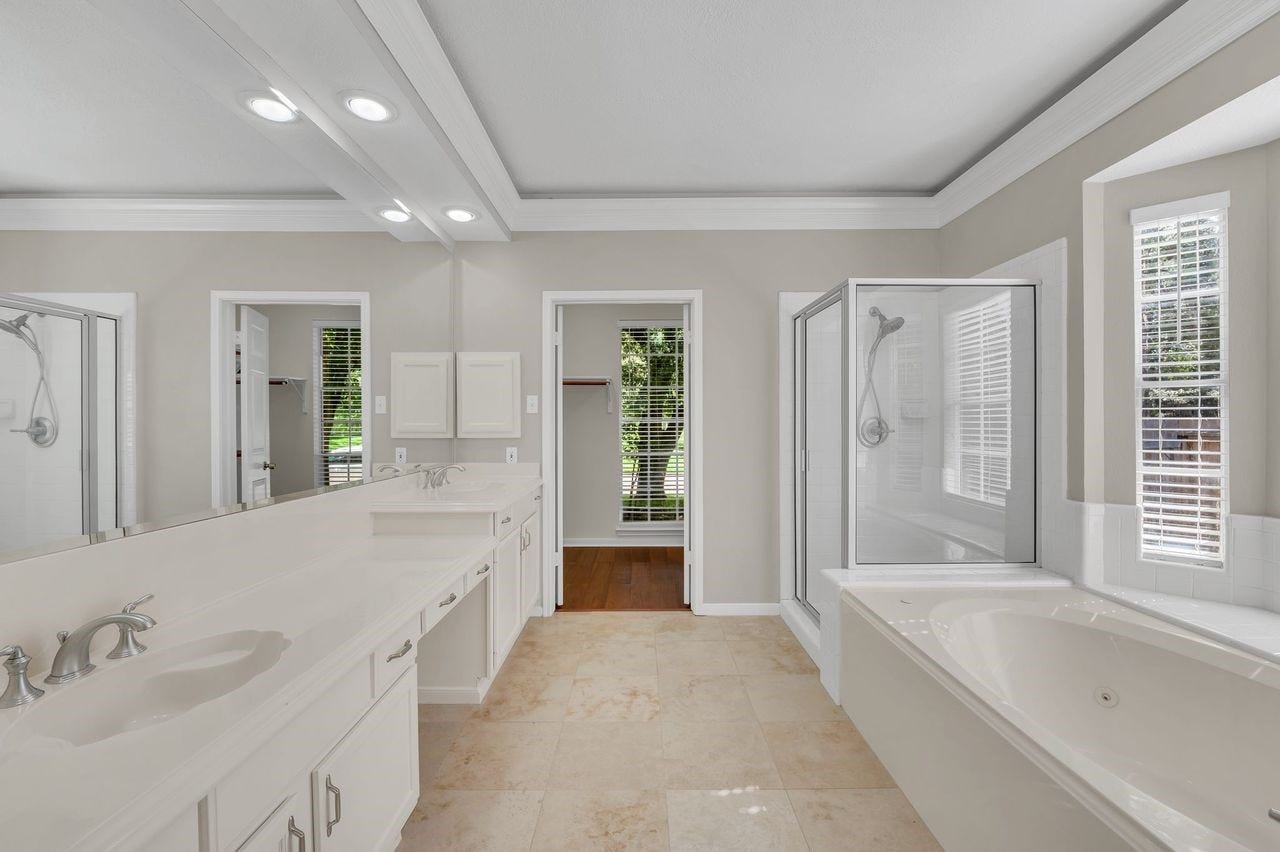 4131 Raven River Drive, Pasadena, TX 77059 Primary bath offers dual vanities, a soaking tub, separate shower and generous storage, creating a comfortable private retreat.