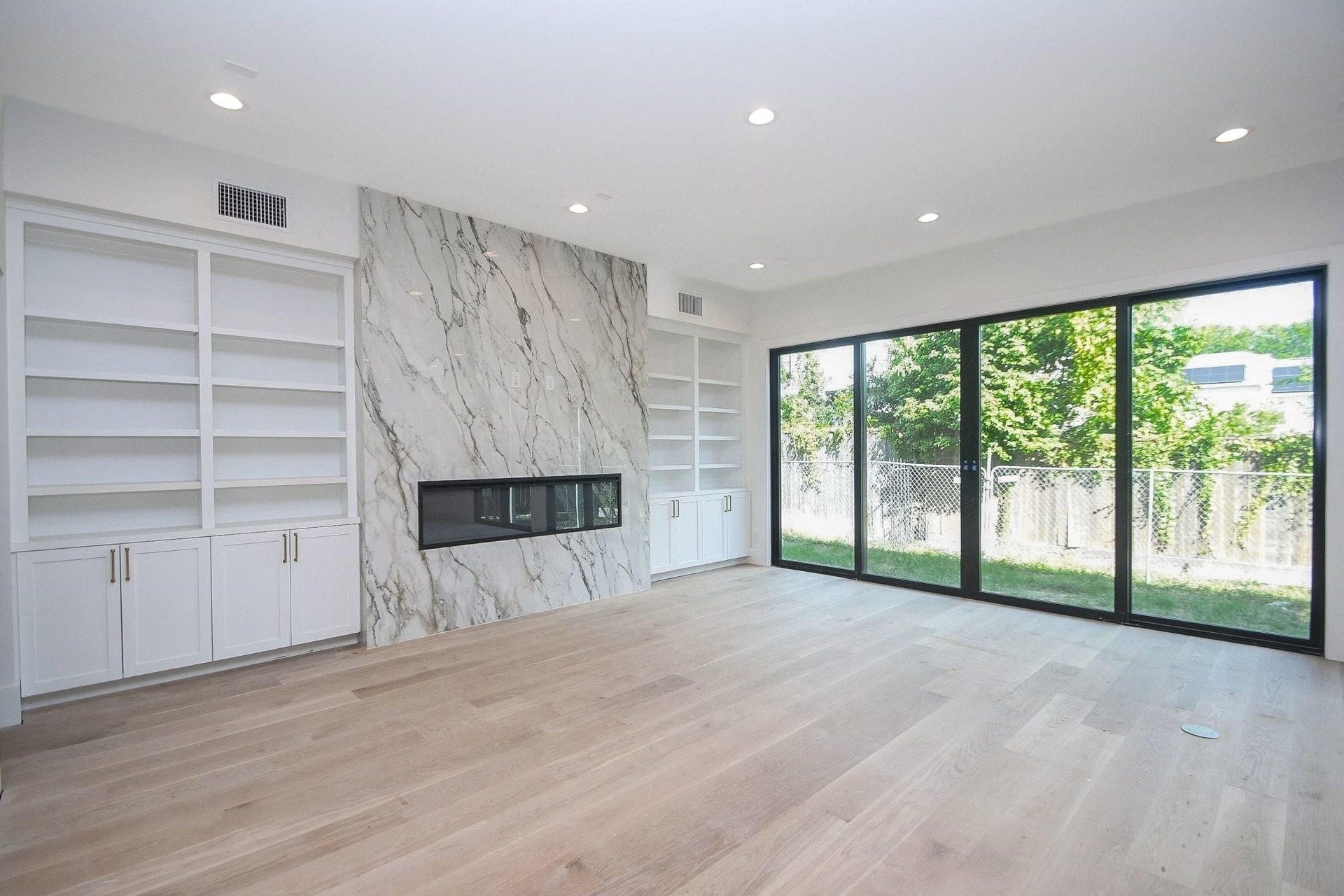 Notice the 4 panel glass doors to the backyard. Custom cabinets and fireplace.  Current stage of construction as of October 2026