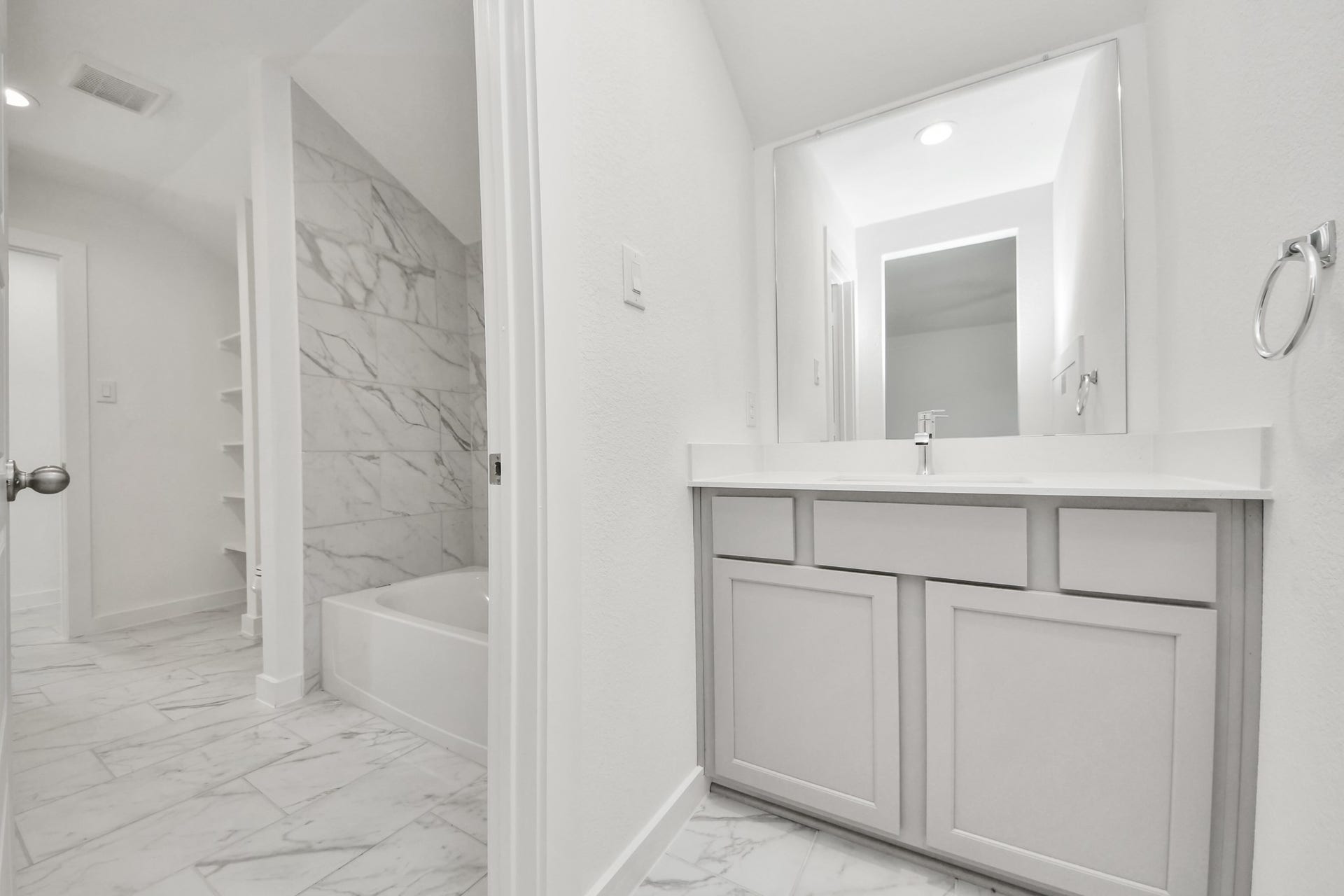 3057 Spoolwood Trail, Magnolia, TX 77355 Experience convenience in the secondary bathroom, designed for Jack and Jill arrangements, now with a separate vanity area. This well-appointed space showcases stylish tile flooring, a bath/shower combo with an elegant tile surround, and light-stained wood cabinets. The beautiful light countertop adds a touch of sophistication, combining functionality and aesthetics seamlessly.