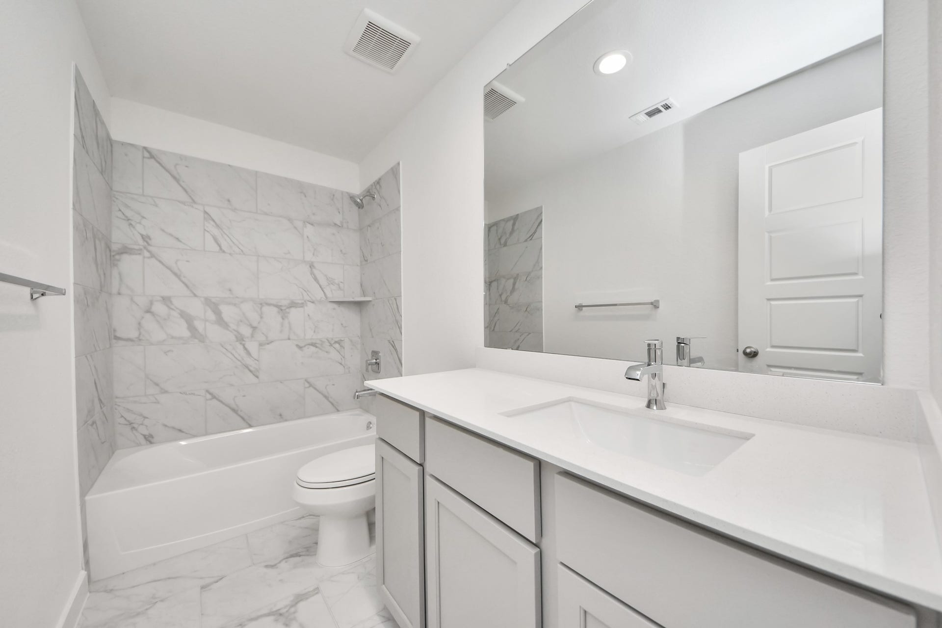 3057 Spoolwood Trail, Magnolia, TX 77355 Secondary bath features tile flooring, bath/shower combo with tile surround, light stained wood cabinets, beautiful light countertop.