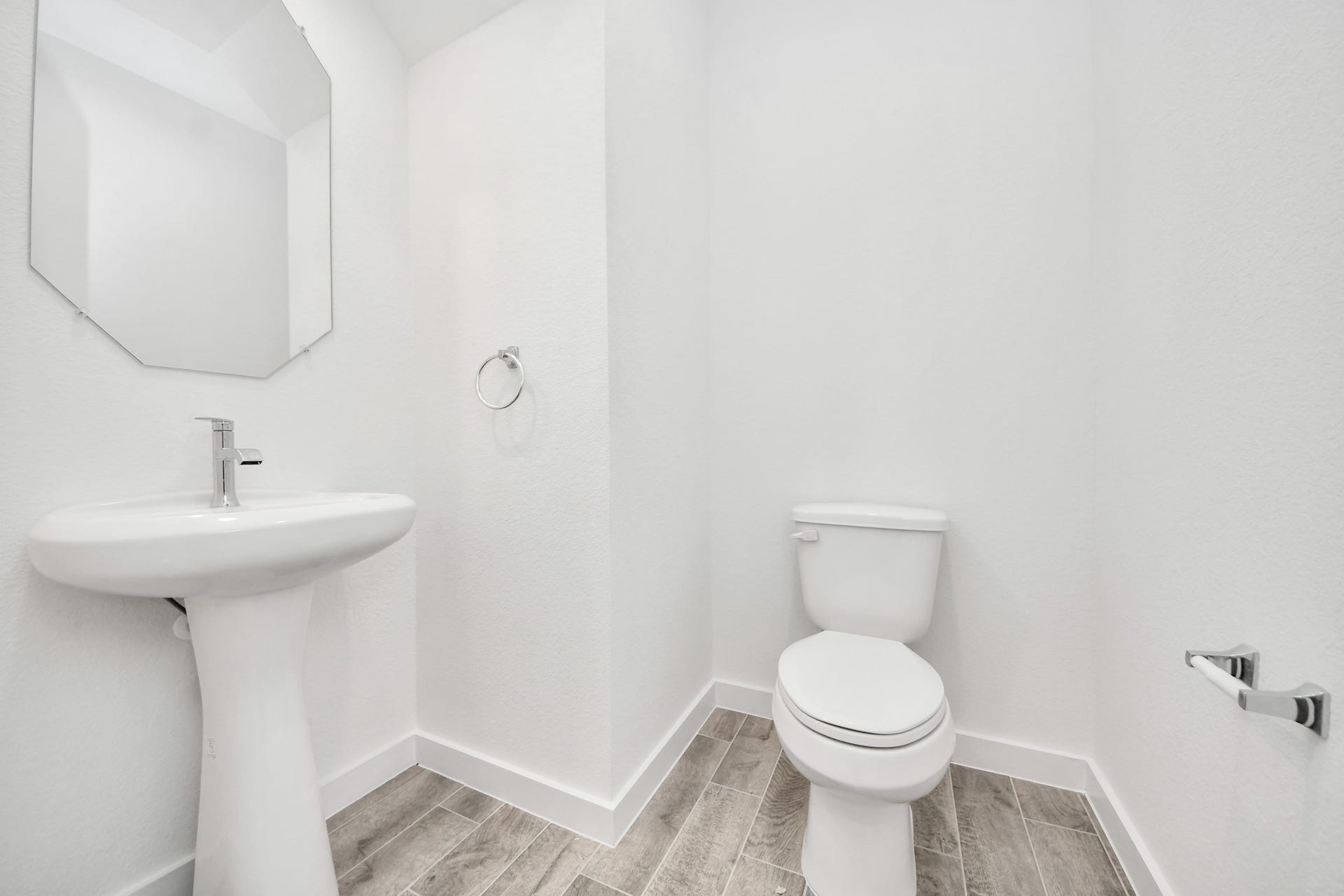 3057 Spoolwood Trail, Magnolia, TX 77355 This half bathroom features a stylish pedestal sink, modern hardware, and bright recessed lighting, creating a sleek and inviting space.