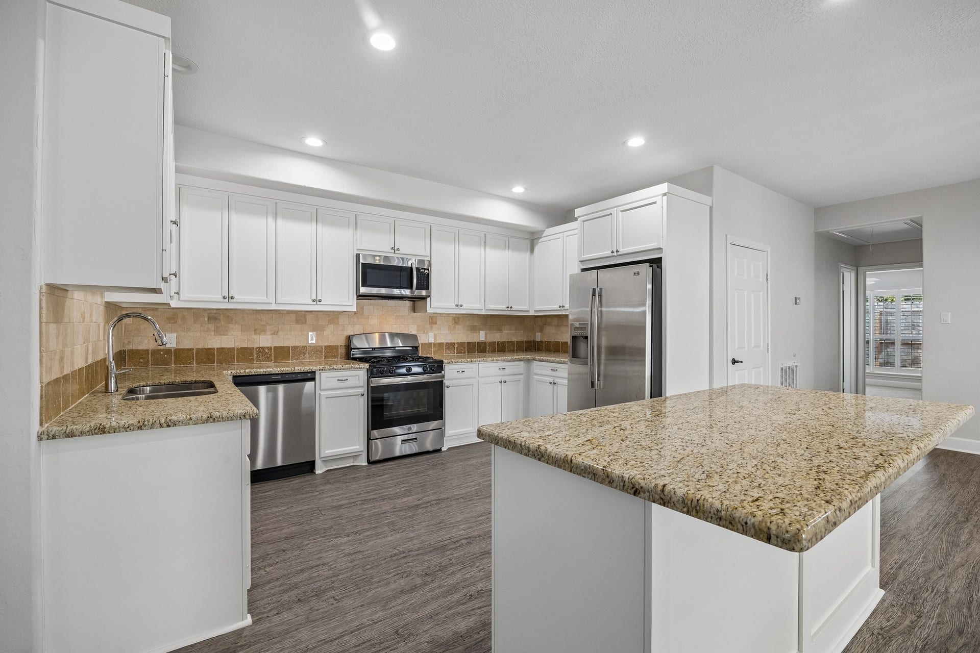Another view of the spacious kitchen with a large eat-at granite island. Perfect for entertaining or everyday use.