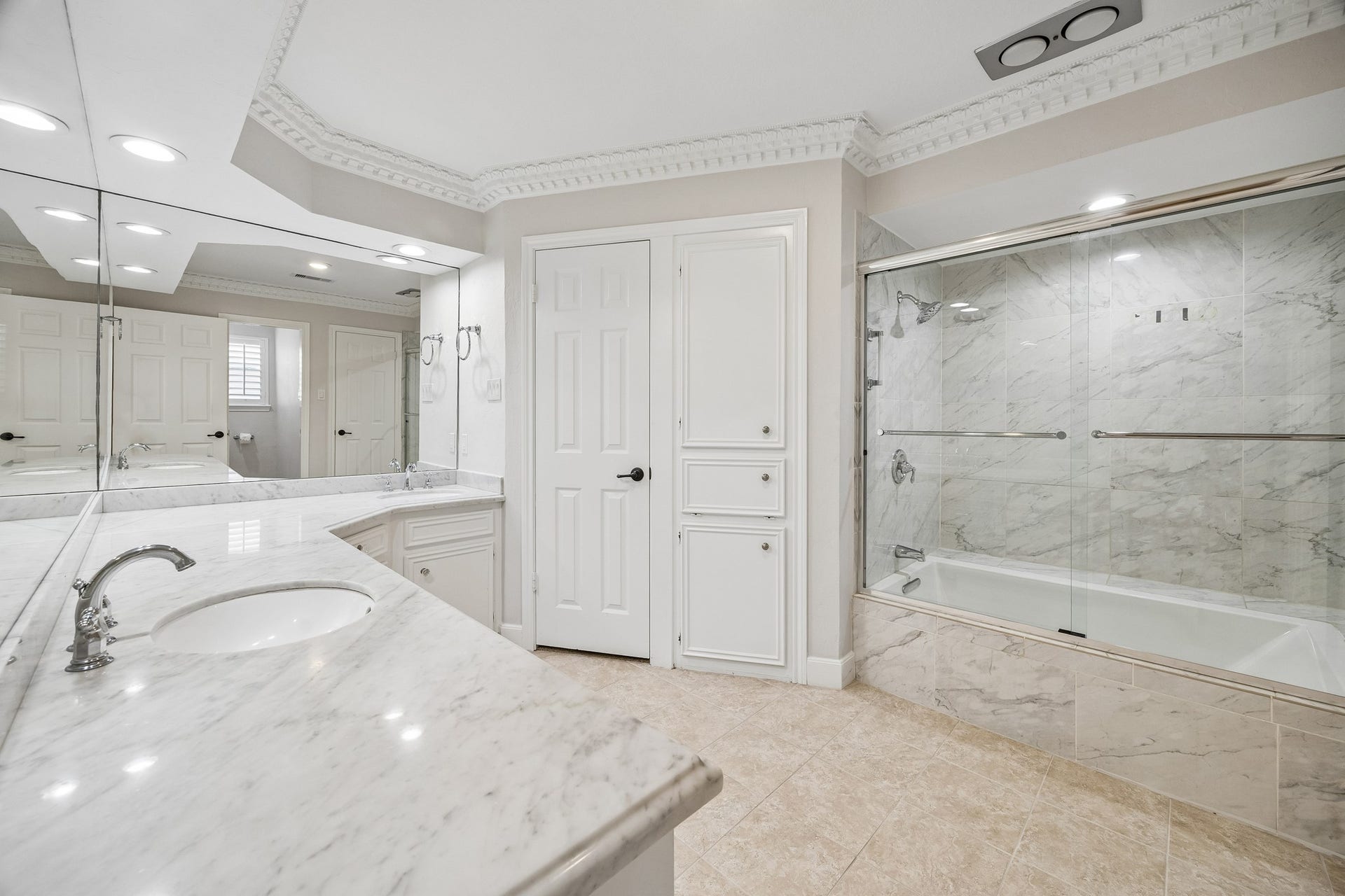 Primary bathroom with large soaking tub and enclosed shower, dual sinks, cultured marble counters, and dual closets.