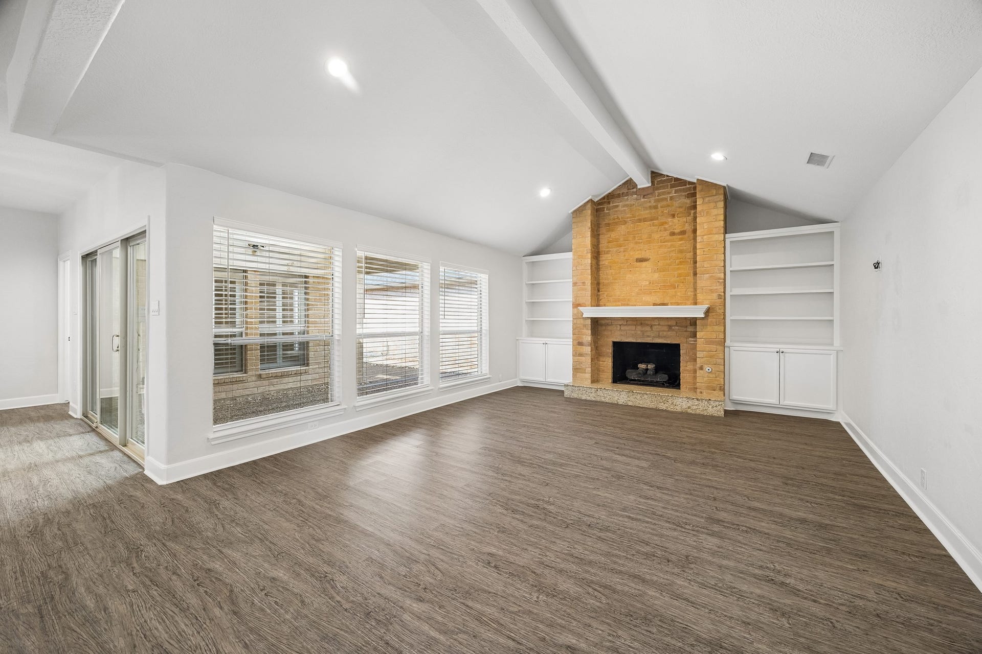 Family room with gaslog fireplace and storage. Views of the covered back patio with sliding glass door.