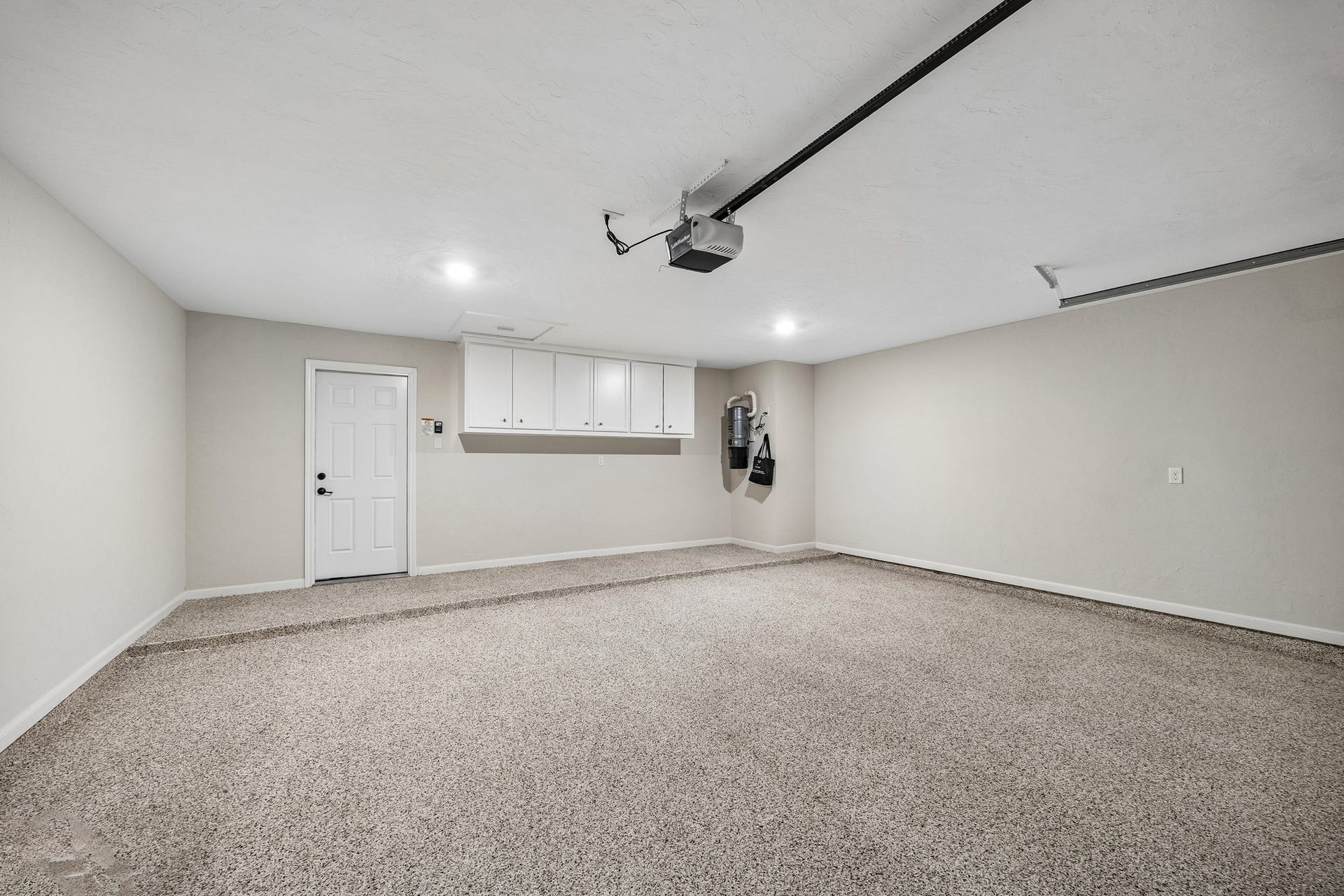 2-car attached garage with epoxy flooring, storage cabinets, and central vacuum for added convenience.