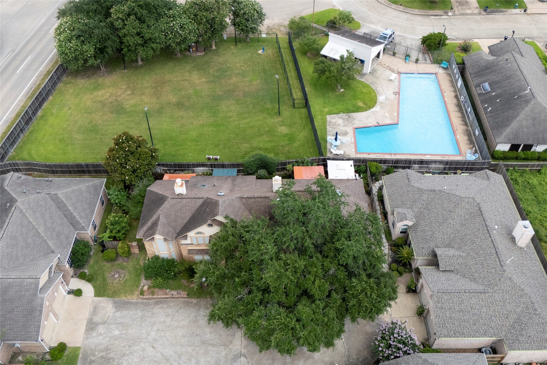 An aerial drone view showcasing the home's location within the Stonehenge community, just steps from the neighborhood pool and green space  a great lifestyle perk for future homeowners.