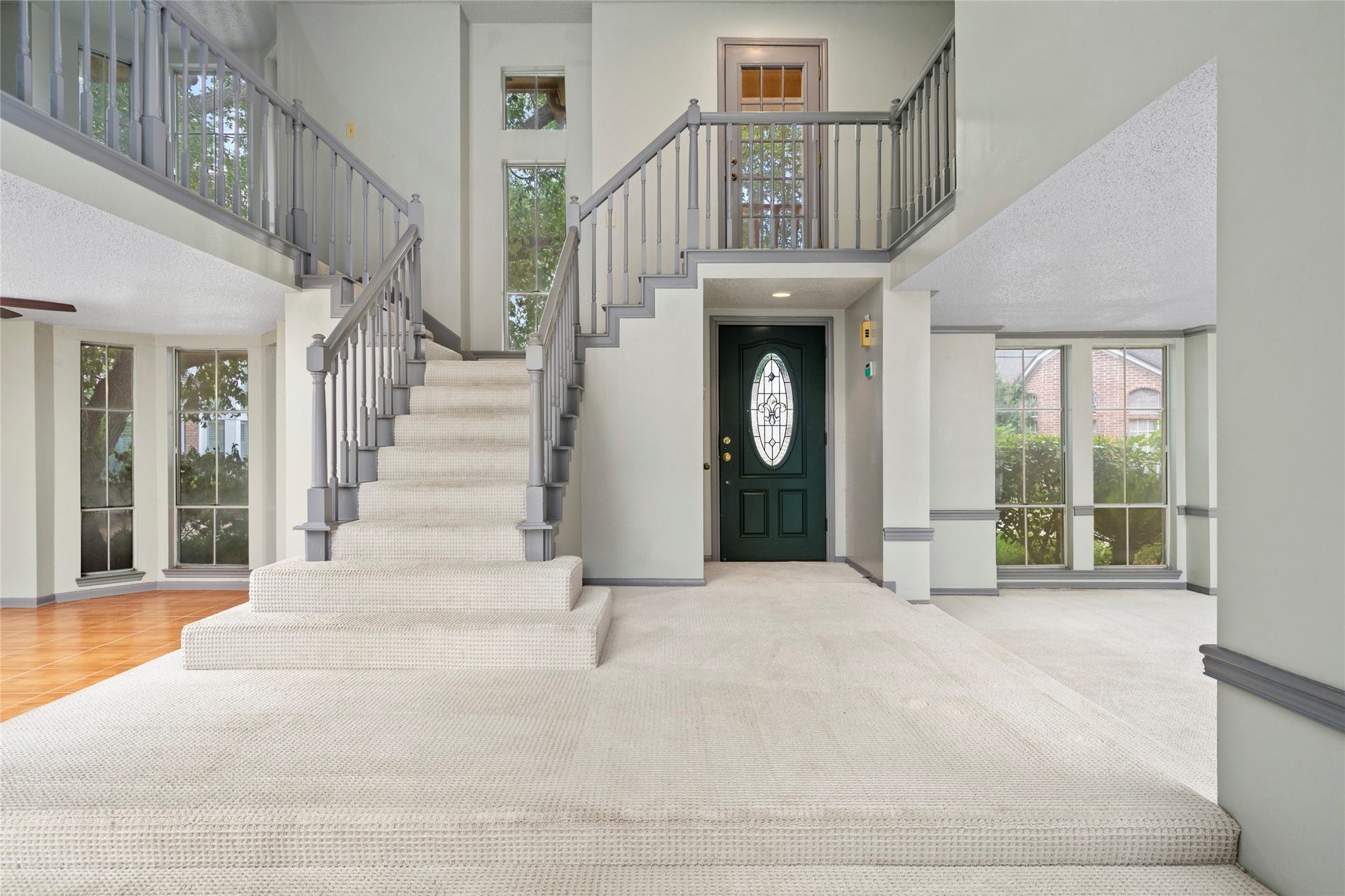 The dramatic two-story foyer, where soaring ceilings and a graceful staircase set an impressive tone the moment you step inside.