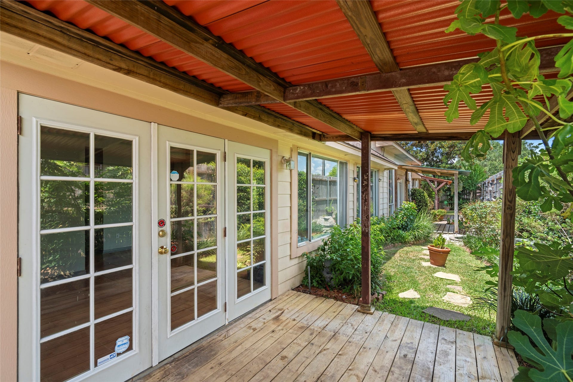 A view through the French doors onto the covered porch, highlighting the seamless indoor-outdoor connection.