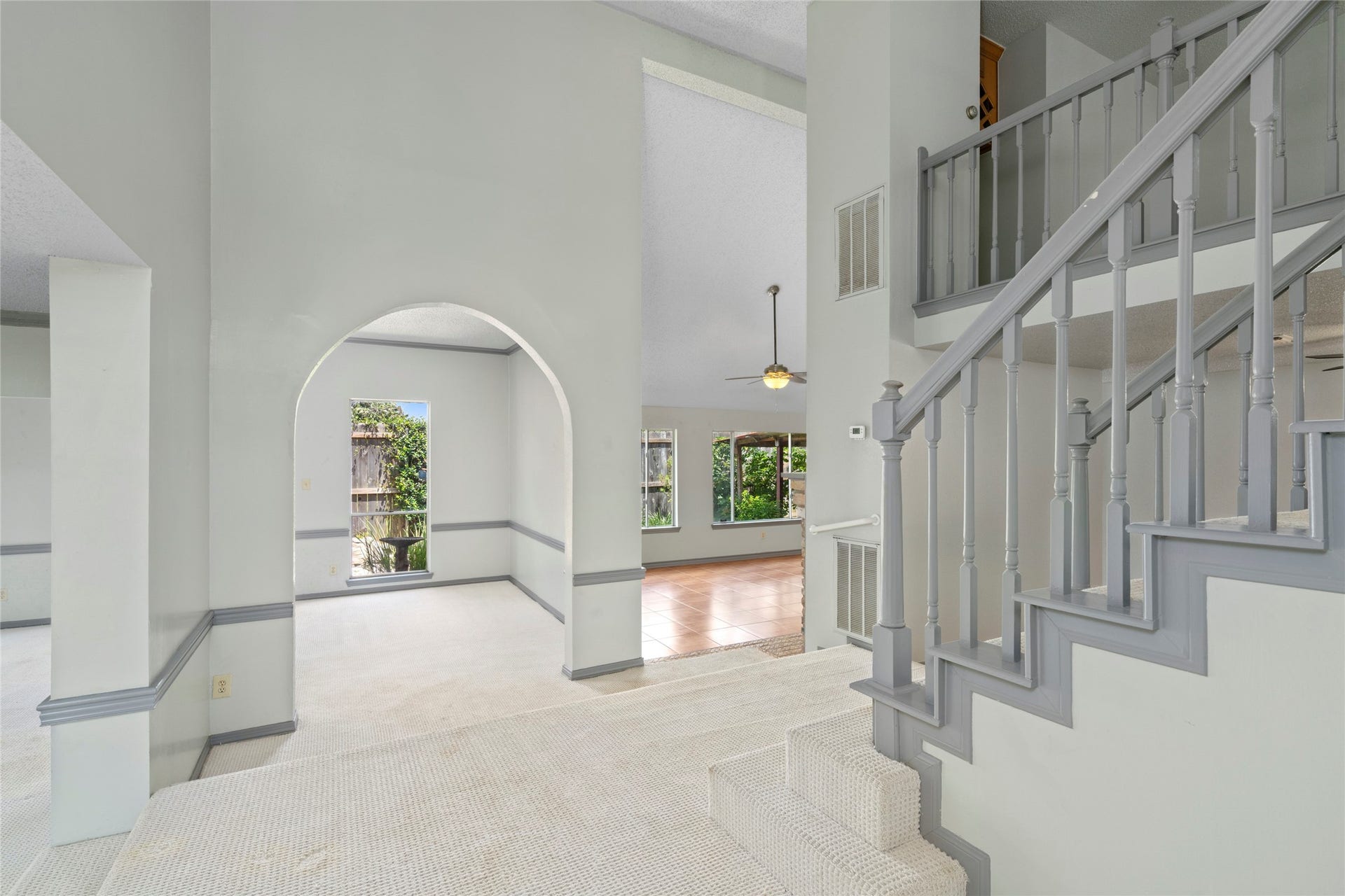 A view of the entry hallway leading toward the staircase, showing the flow and openness that connects the front of the home to the living spaces beyond.