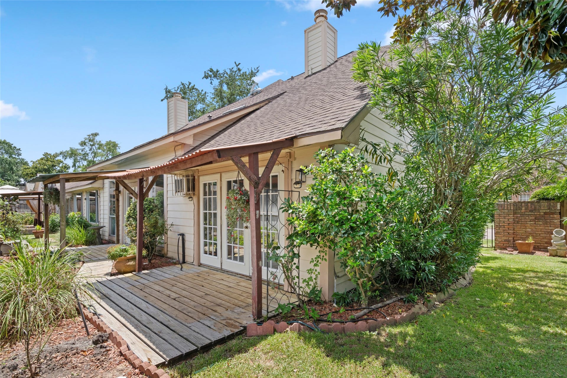 The backyard, framed by a pergola and open lawn, providing a private setting for outdoor activities or relaxation.