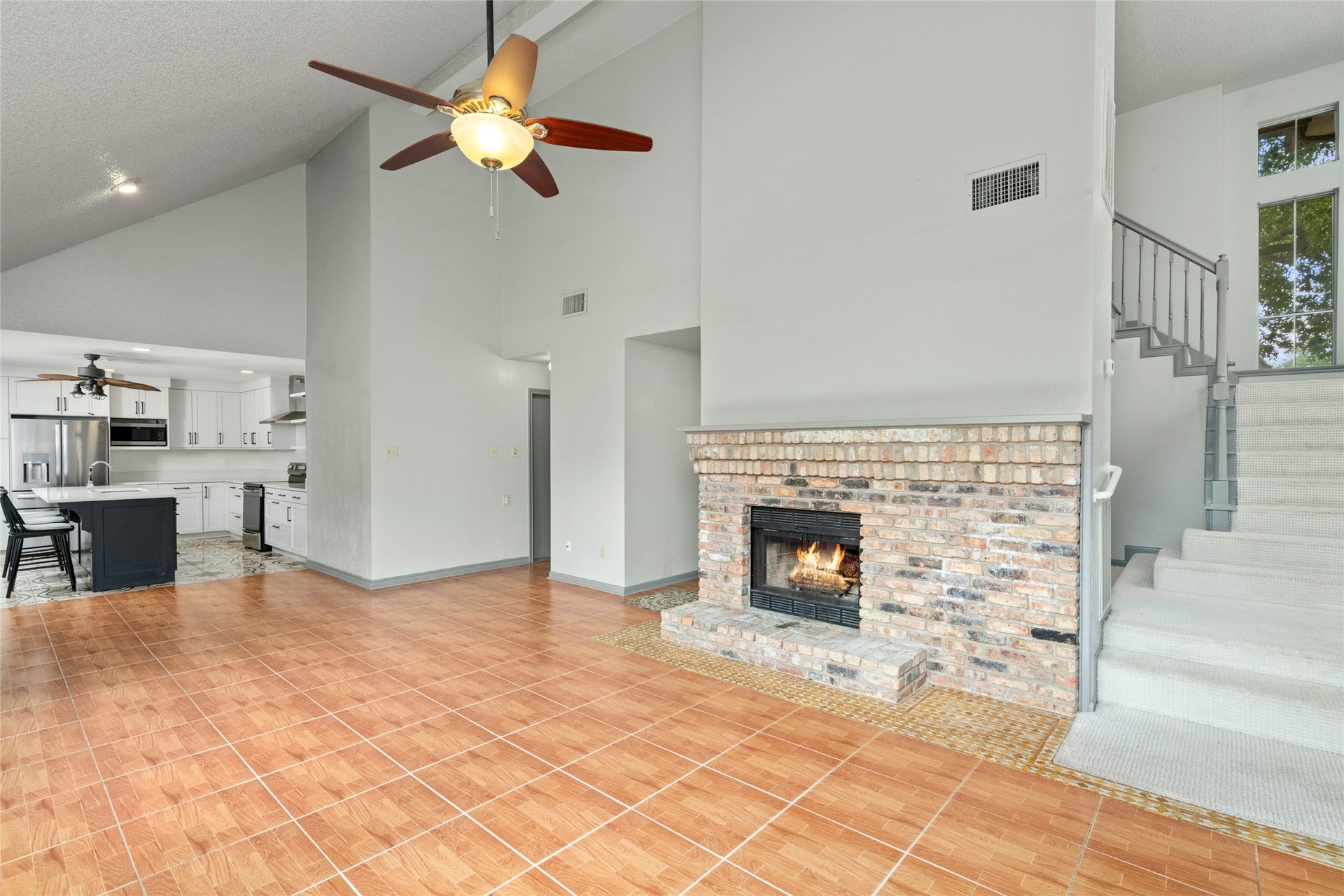 The vaulted living area with its cozy fireplace, illustrating how the high ceilings and open sightlines make this the heart of the home.