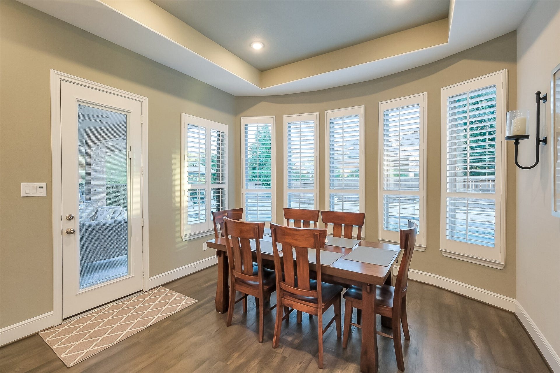 Wrapped in plantation-shuttered windows, this curved casual dining area is the perfect spot to gather with friends and family. A door leads directly out to the covered patio, making indoor-outdoor dining and entertaining effortless.