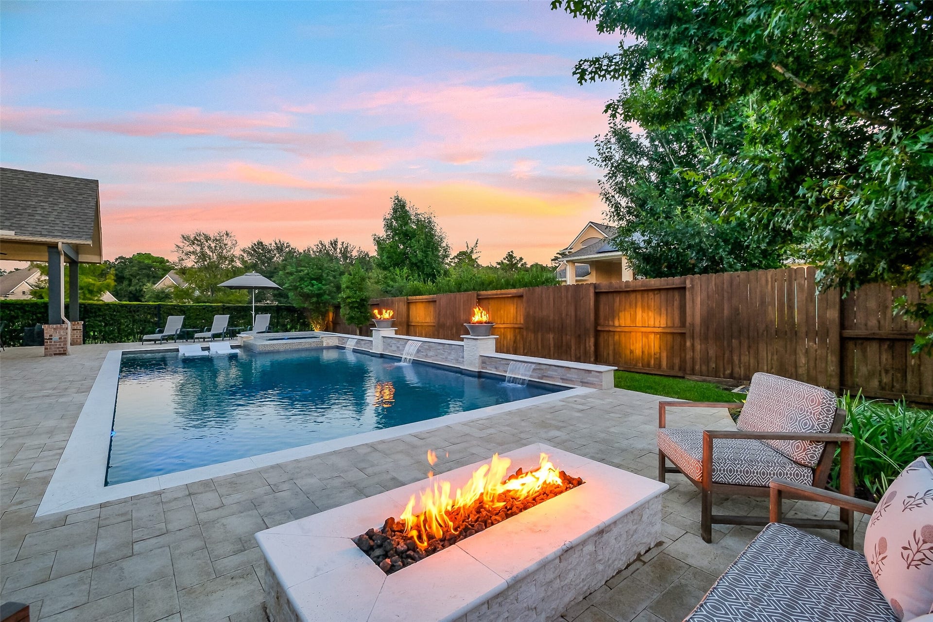 When the weather cools, youll appreciate the built-in linear firepit overlooking the pool and spa. The fire bowls, water features, and landscape lighting add to the ambiance for relaxed evenings in this backyard retreat.