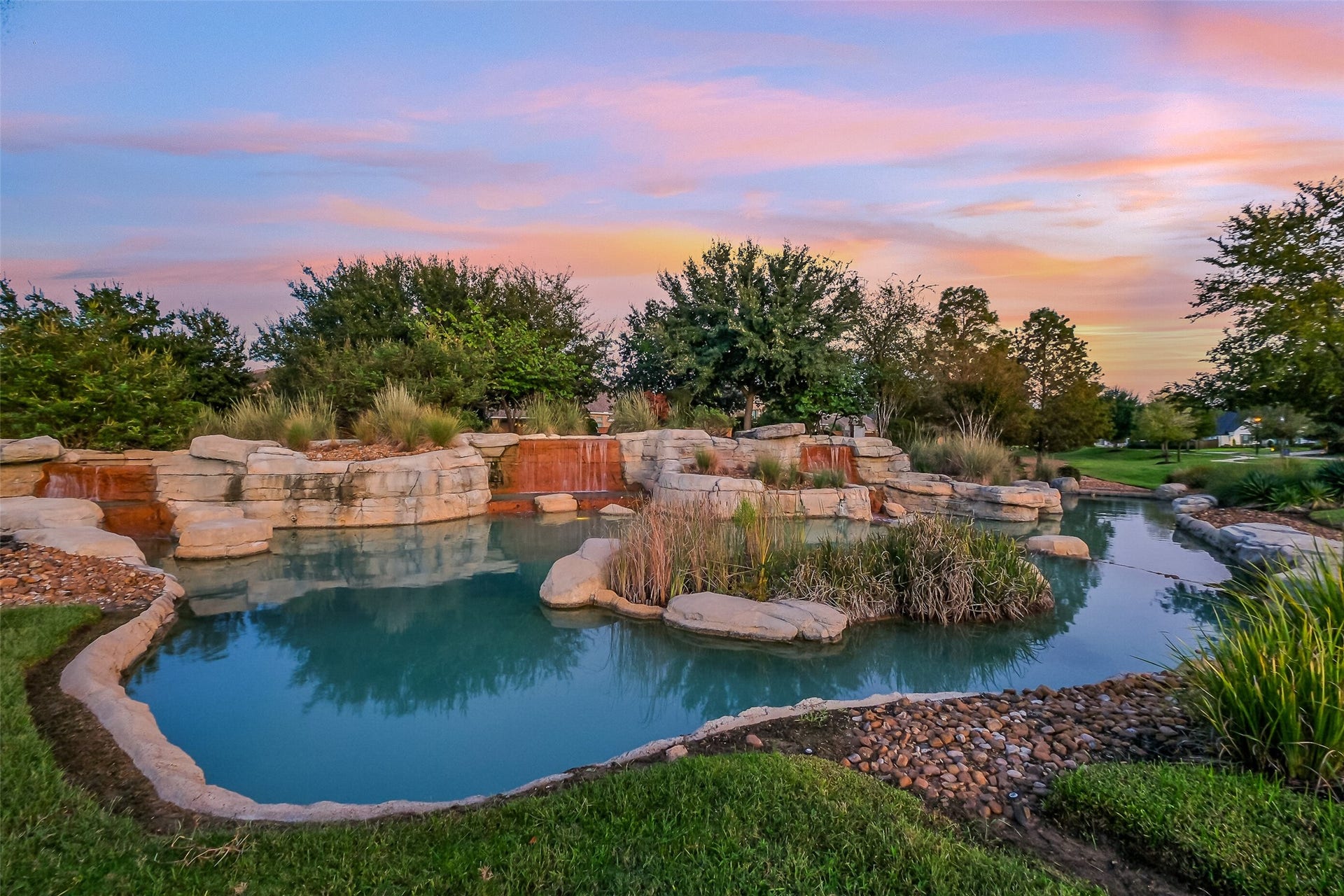 A rock waterfall and natural-style water feature create a tranquil focal point as soon as you enter the neighborhood.