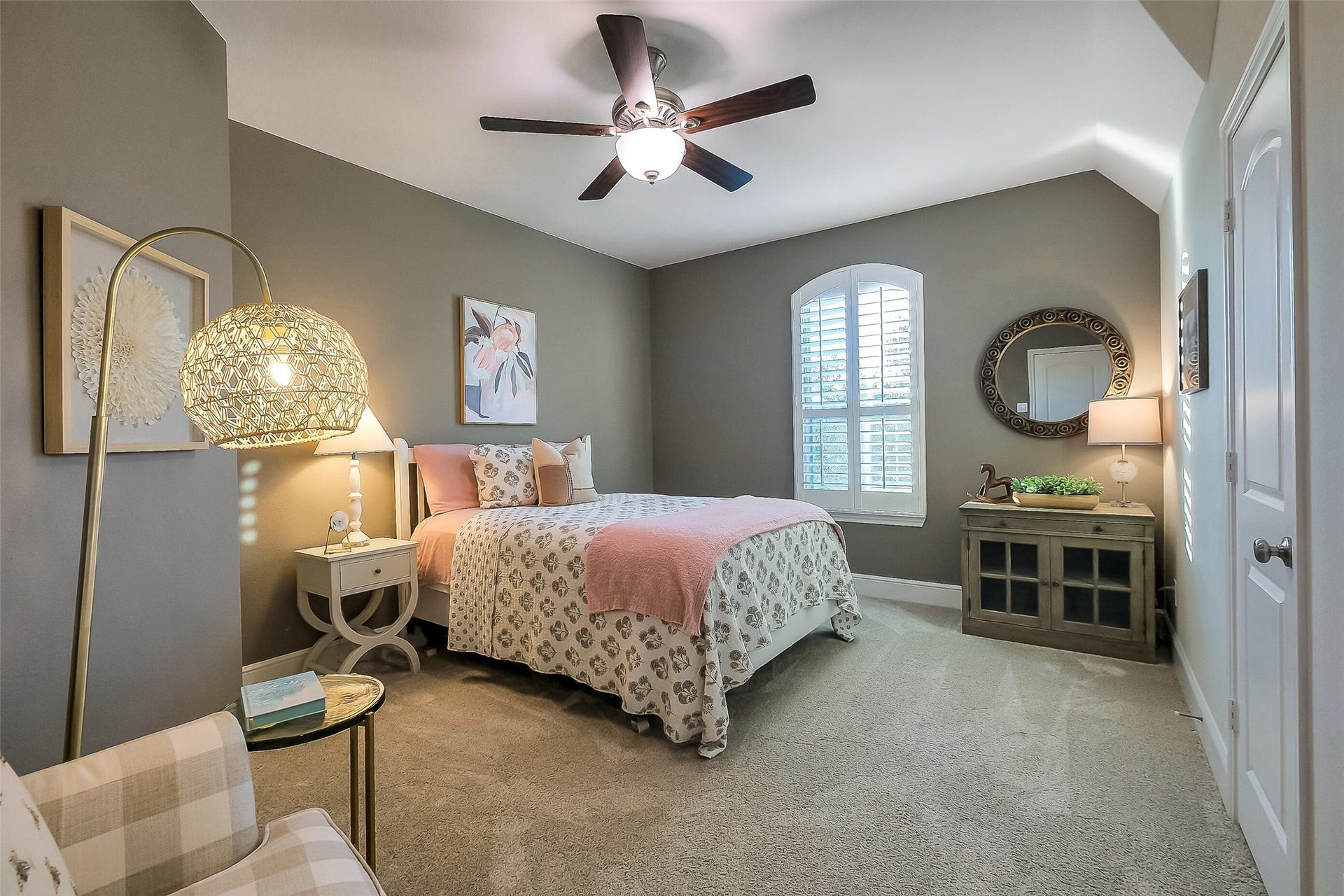 Secondary bedroom featuring plantation shutters, ceiling fan, plush carpet, neutral paint and a large walk in closet.