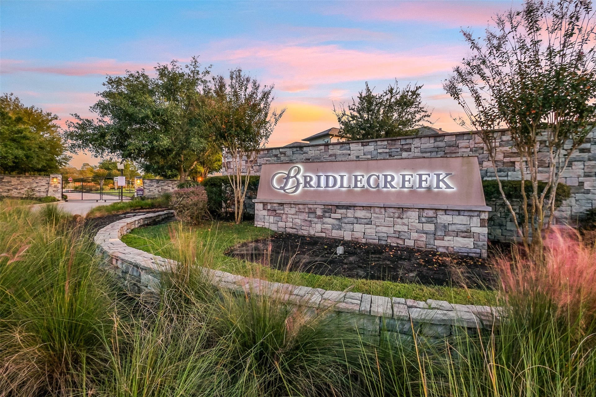 The community's stone entrance sign and gated drive reflect the quiet, manicured feel of the neighborhood  a fitting welcome home.