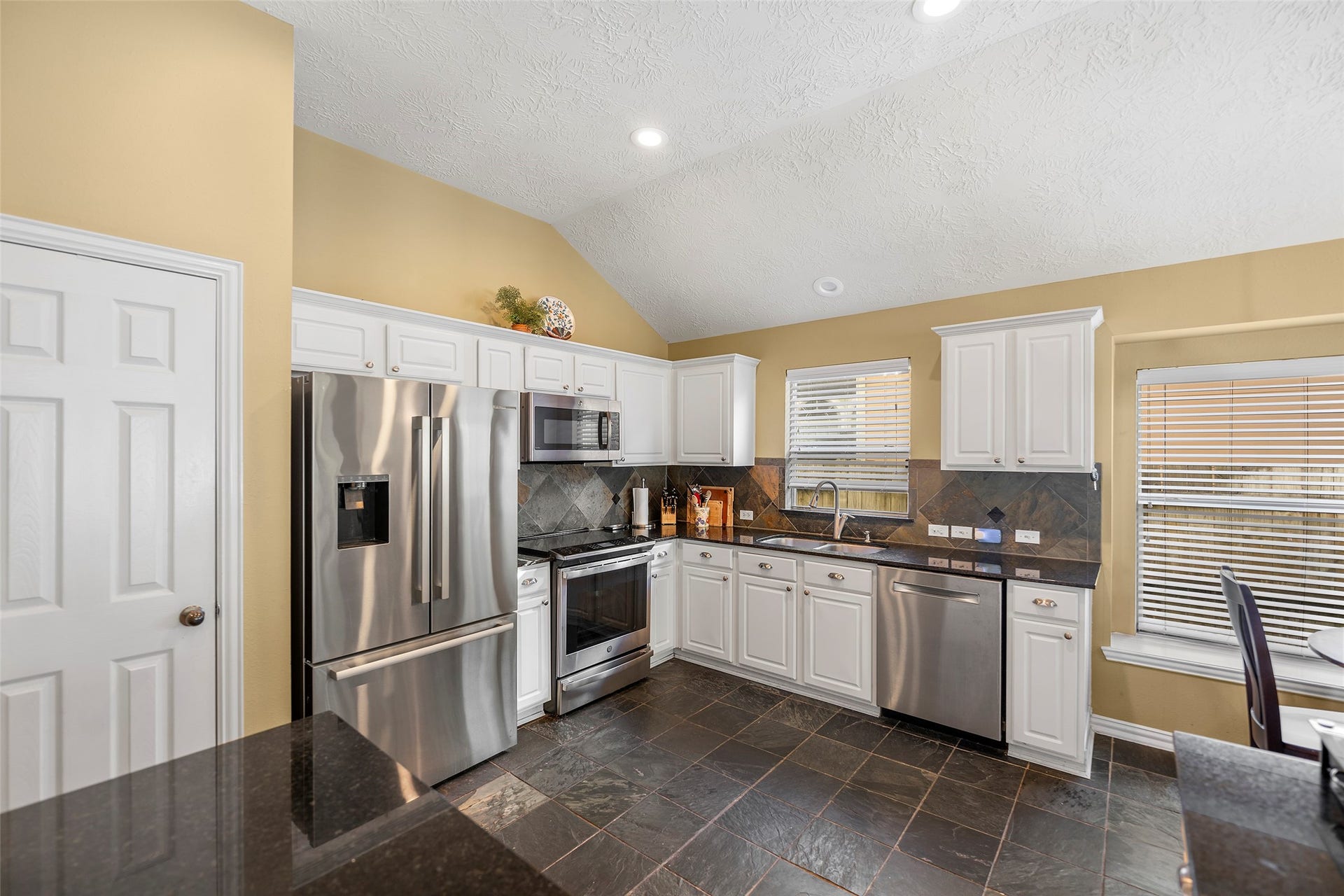 Another view of the stainless steel appliances. Notice the slate tile throughout the kitchen.