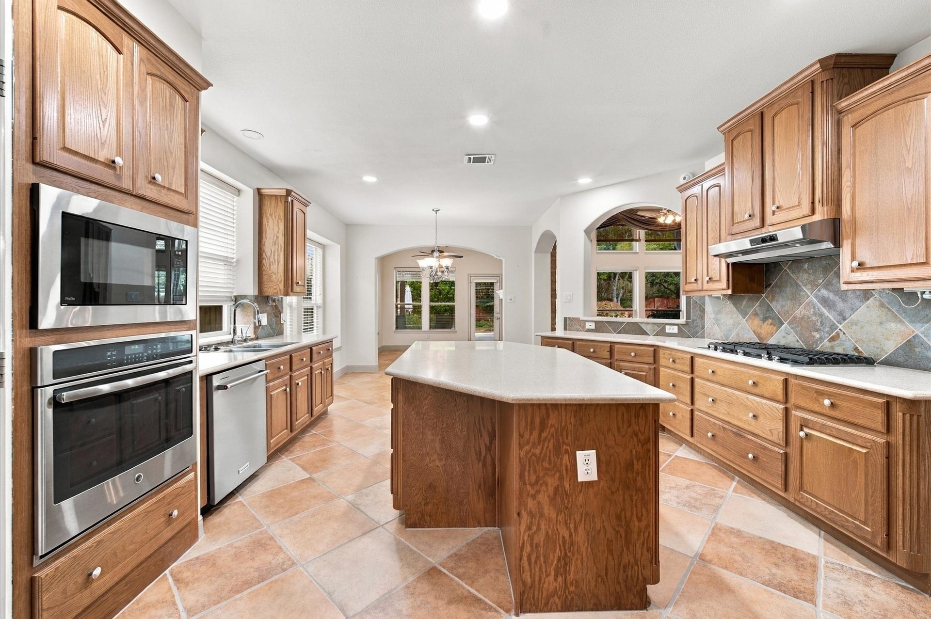 4427 Shady River, Missouri City, TX 77459 Spacious kitchen with elegant wood cabinetry, stainless steel appliances, and a large central island, perfect for entertaining and family gatherings.