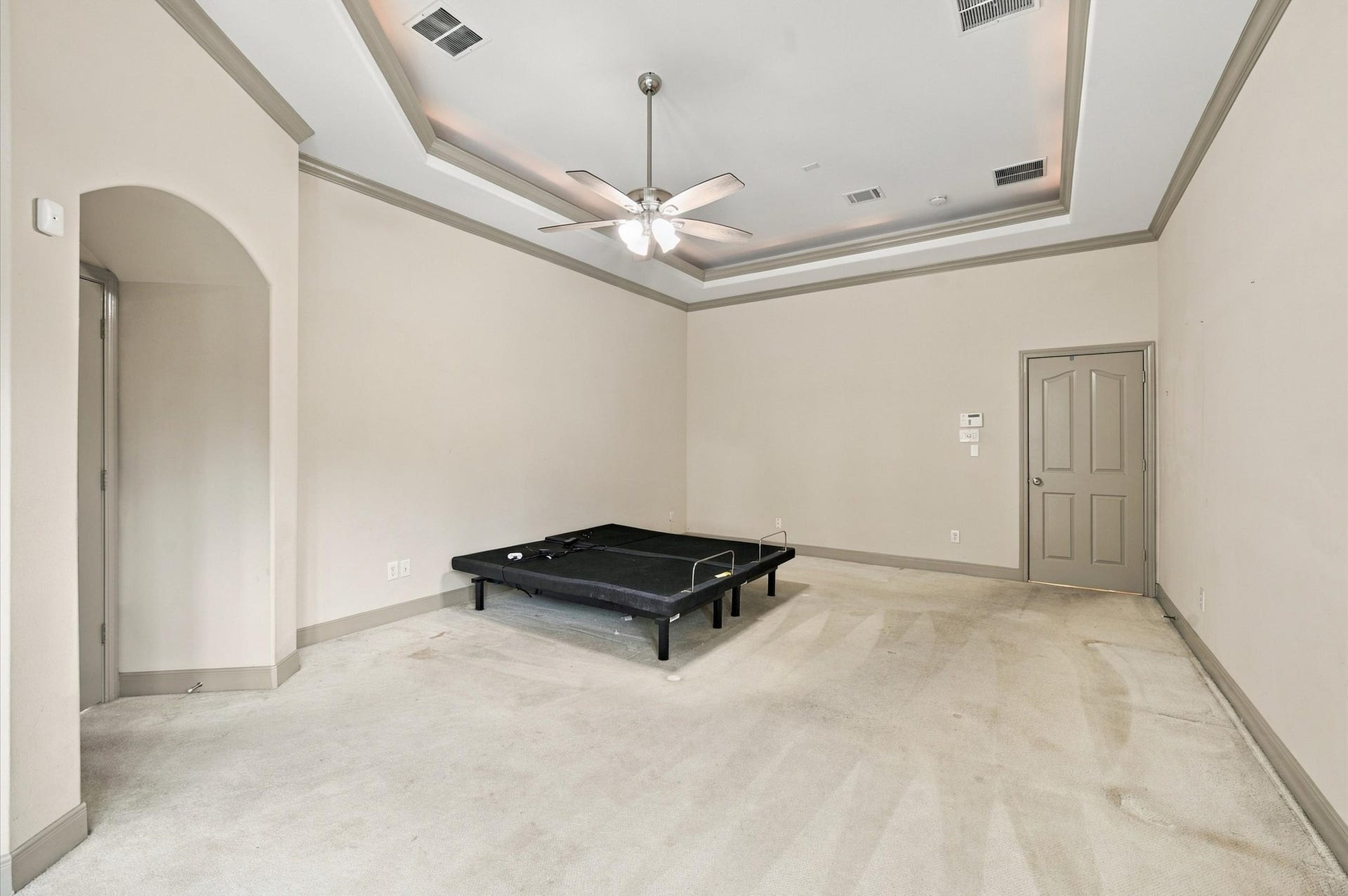 4427 Shady River, Missouri City, TX 77459 Spacious bedroom with elegant tray ceiling, ceiling fan, and neutral tones, offering ample potential for personalization.