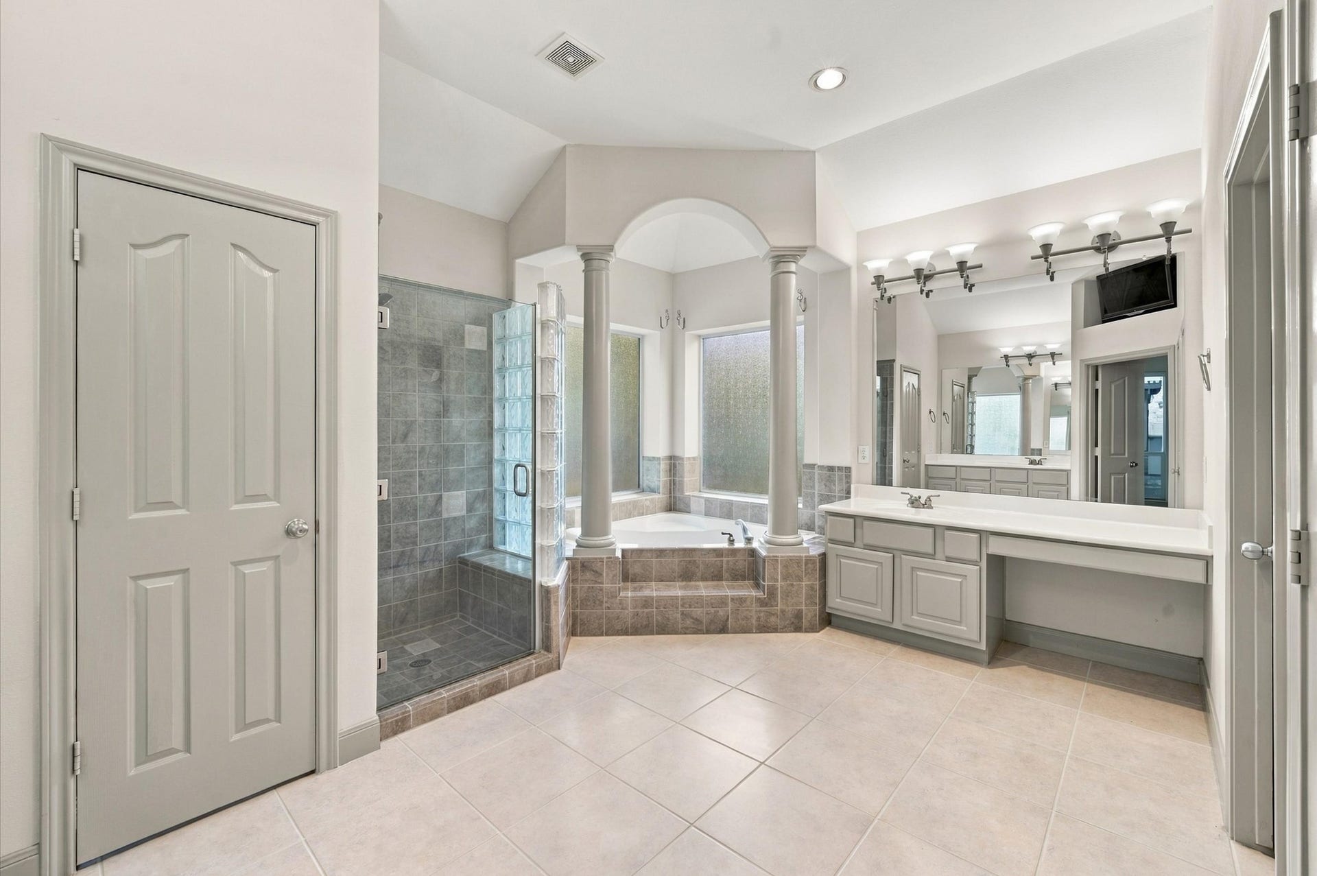4427 Shady River, Missouri City, TX 77459 Spacious and elegant bathroom featuring a large walk-in shower, soaking tub with columns, dual vanities, and abundant natural light.