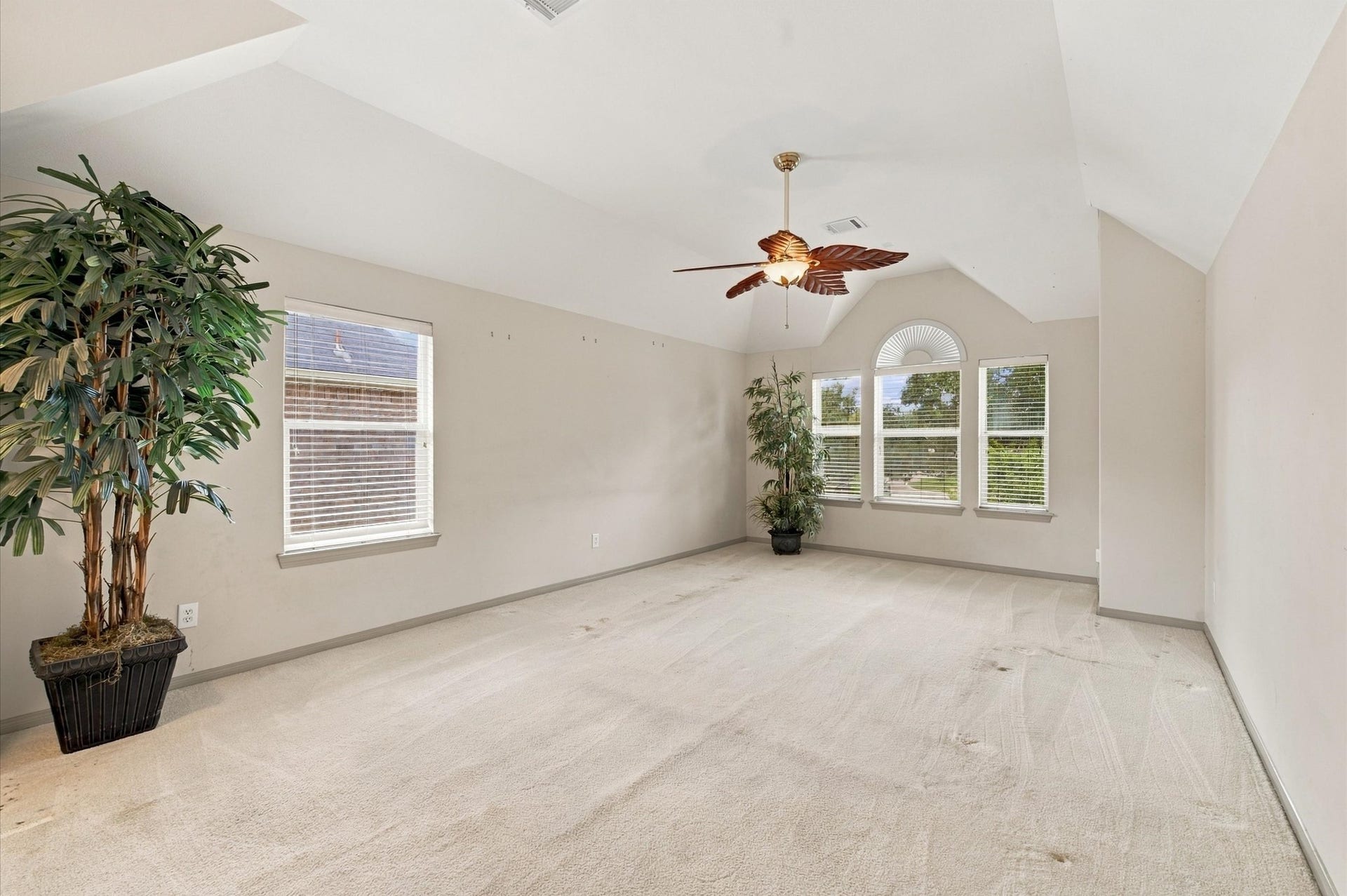 4427 Shady River, Missouri City, TX 77459 Bright and spacious room with vaulted ceilings, large windows for natural light, and a stylish ceiling fan, perfect for versatile use.