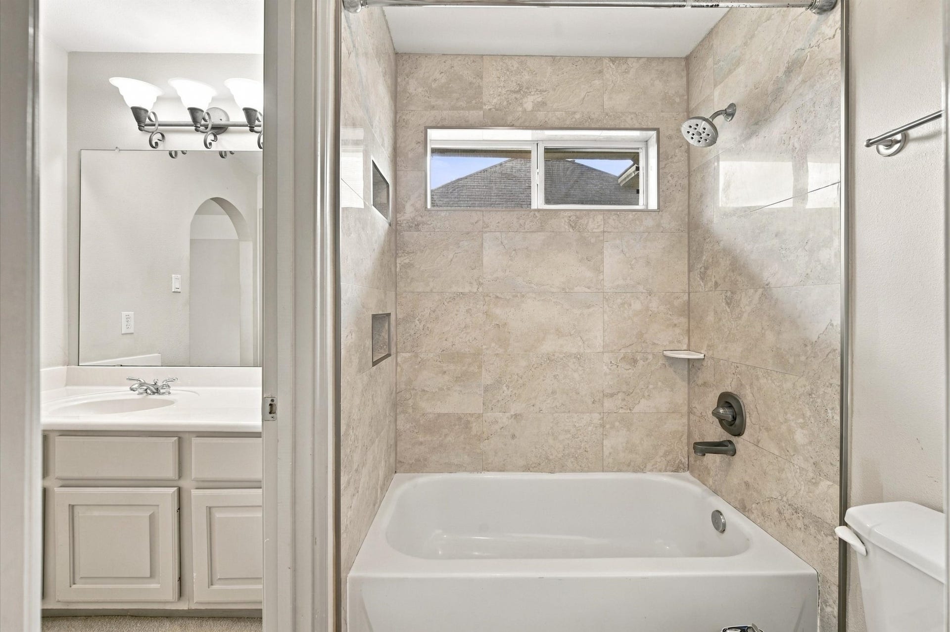 4427 Shady River, Missouri City, TX 77459 Elegant bathroom featuring a tiled shower and tub combo, complemented by a modern vanity and sleek lighting.