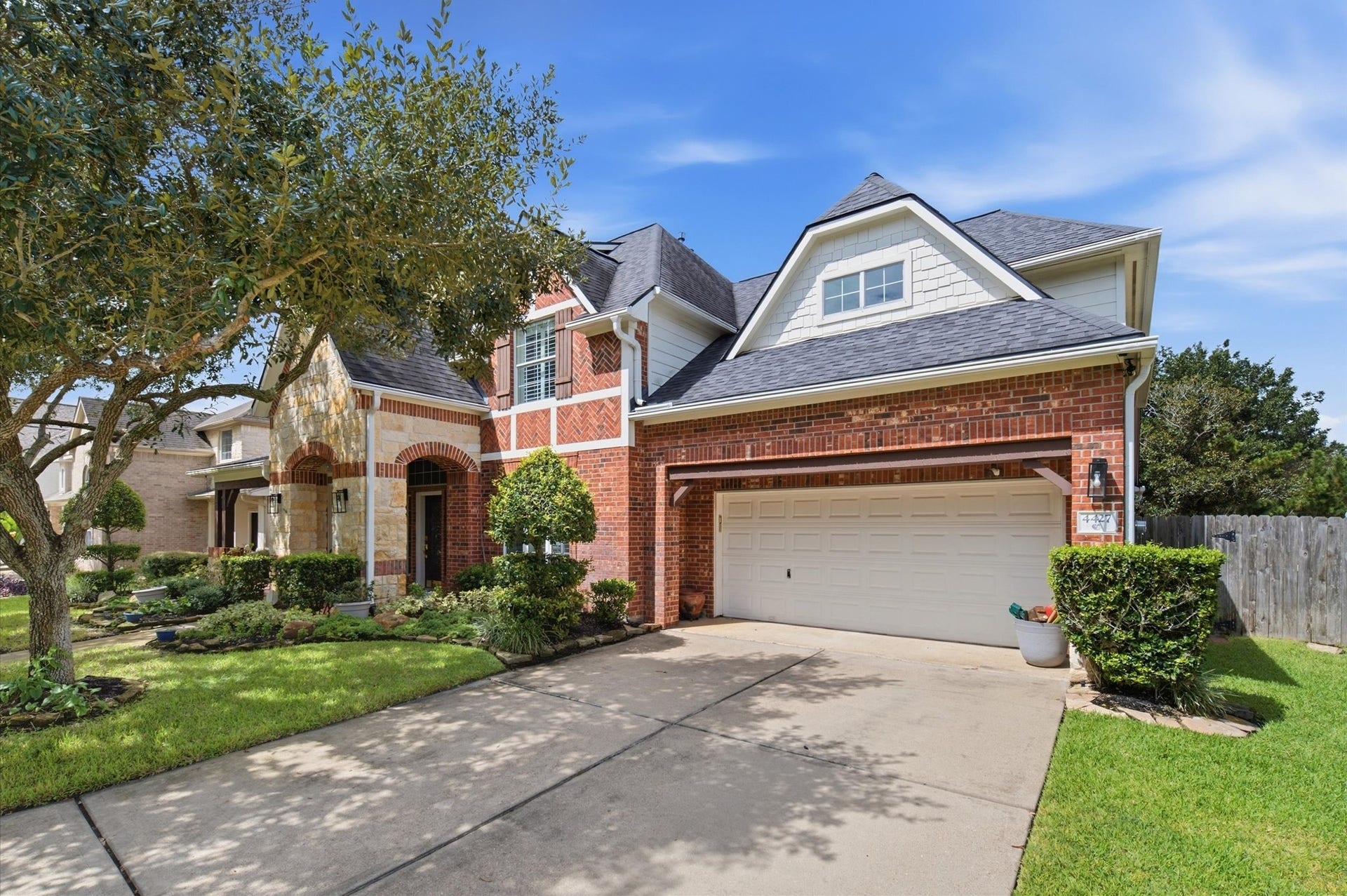 4427 Shady River, Missouri City, TX 77459 Charming two-story home featuring a classic brick exterior, a spacious three-car garage, and lush landscaping, set in a serene neighborhood.