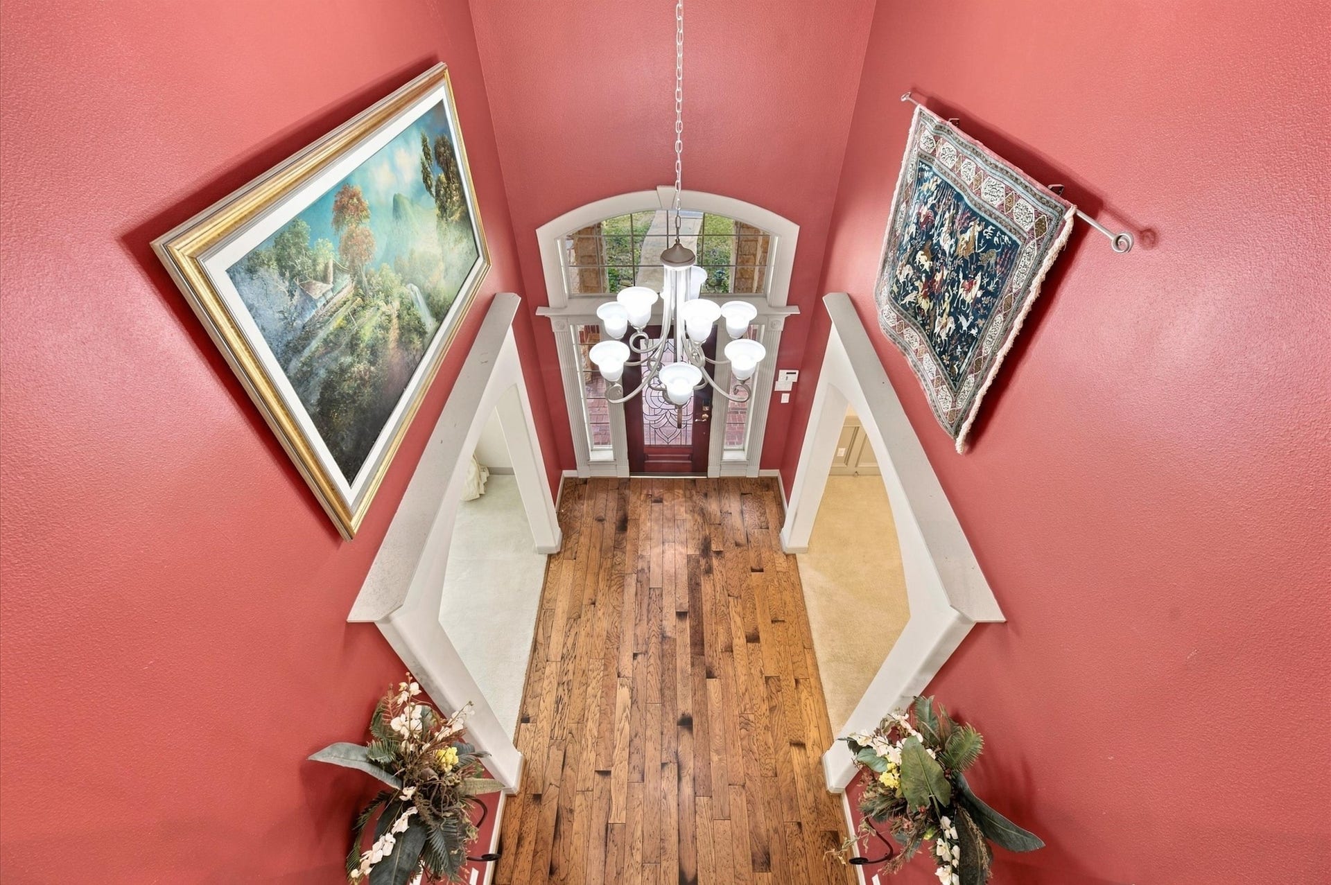 4427 Shady River, Missouri City, TX 77459 Dramatic two-story entryway with rich red walls, elegant hardwood flooring, and abundant natural light from the grand window above the front door.