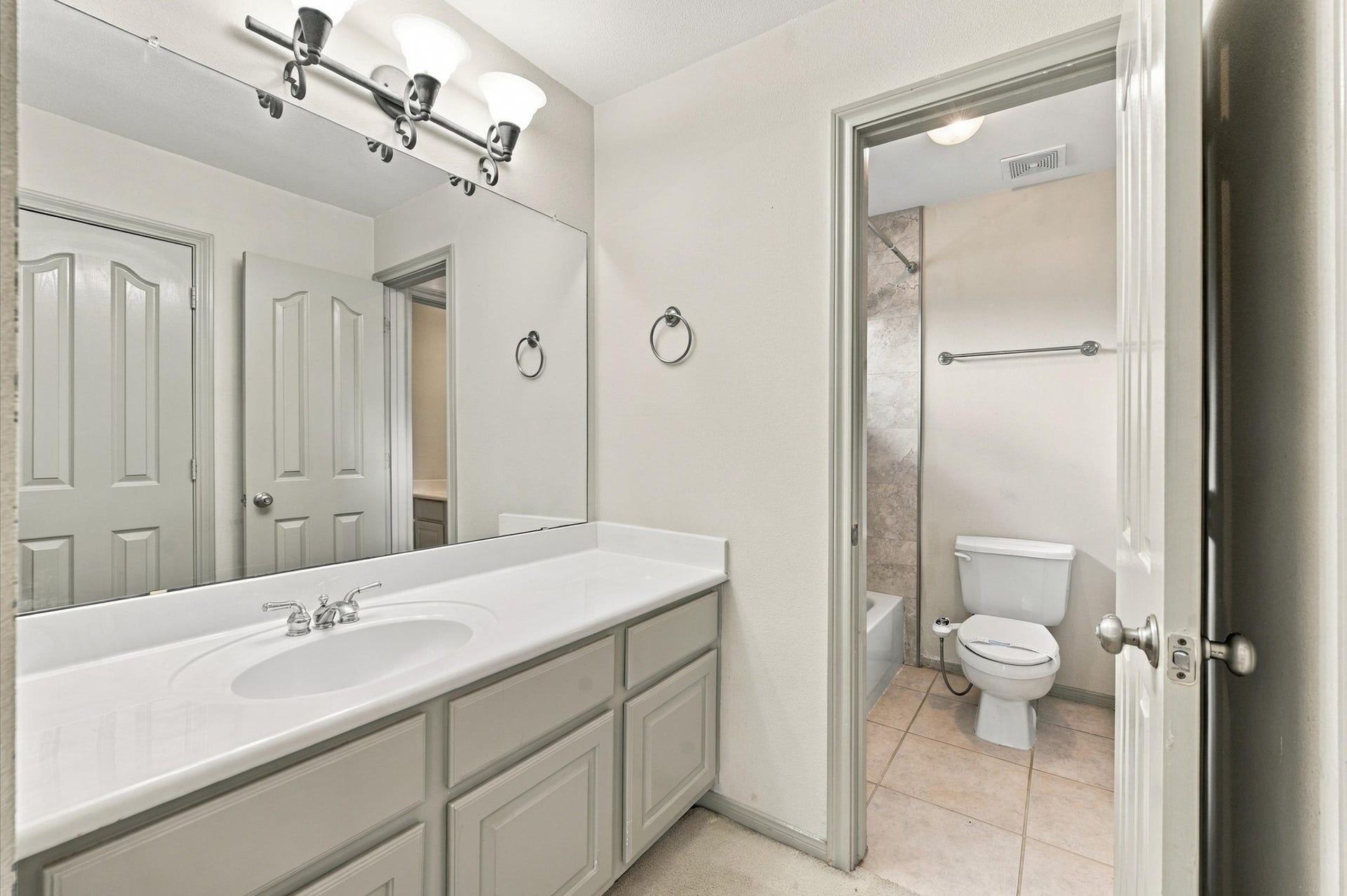 4427 Shady River, Missouri City, TX 77459 Spacious bathroom featuring a large vanity with ample storage, elegant lighting, and a separate area for the toilet and shower, enhancing privacy and functionality.