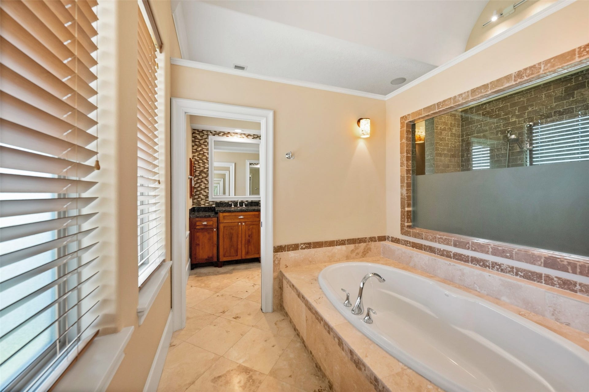 Indulge in the large soaking tub with serene views of the private backyard.