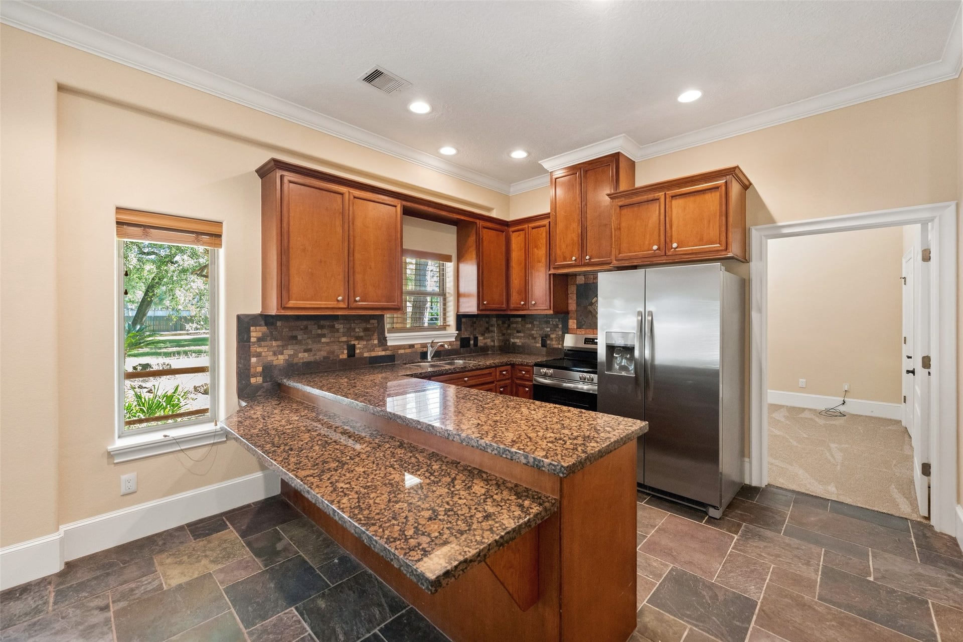 The guest house kitchen boasts a stylish breakfast bar and elegant granite countertops.