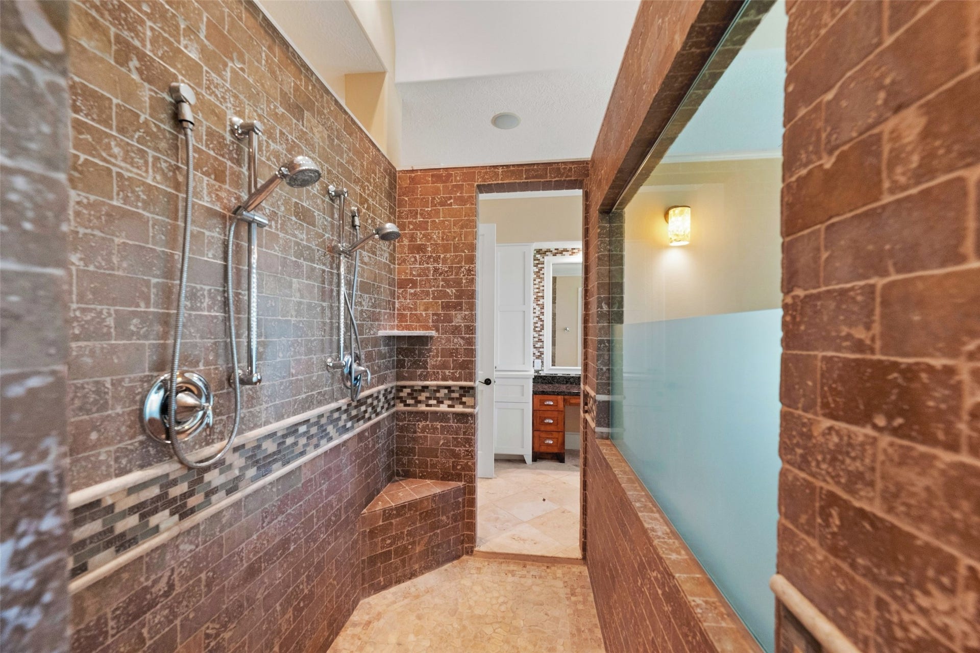 Expansive walk-through shower with dual shower heads and abundant natural light.