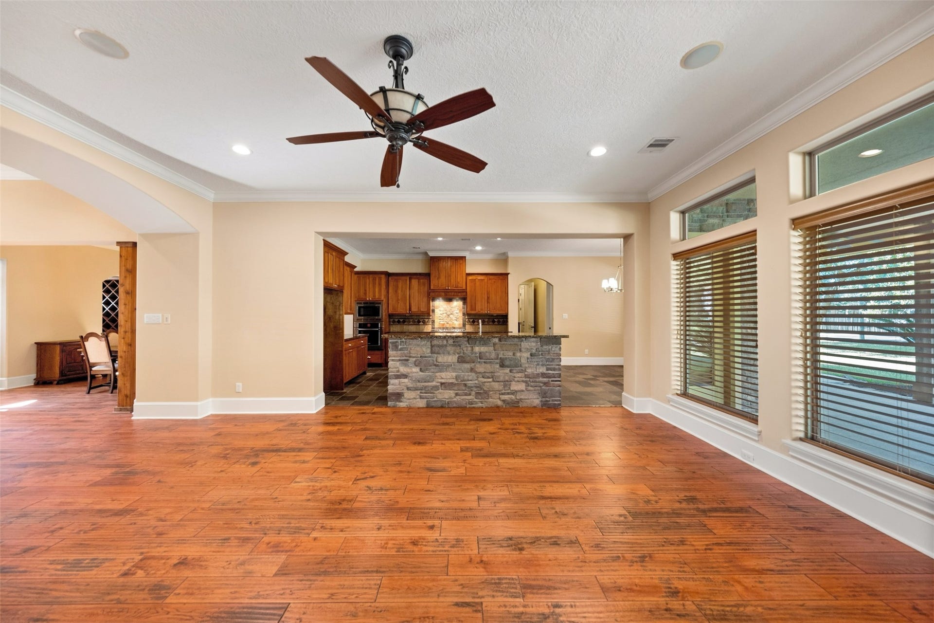 Spacious family room leading into a kitchen with a charming breakfast bar.