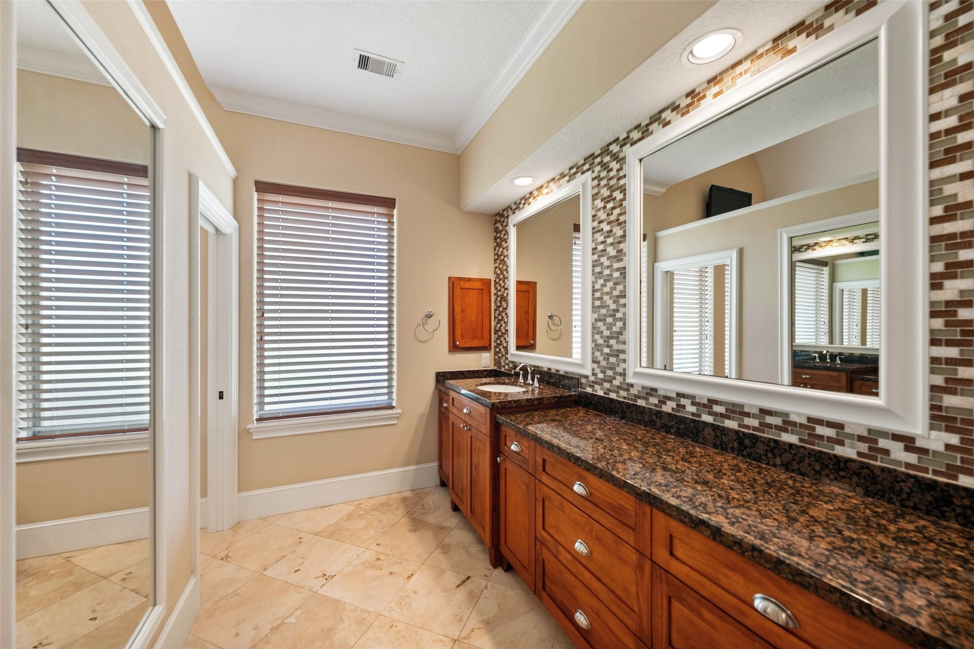 Luxurious en suite primary bath with elegant double granite vanities.