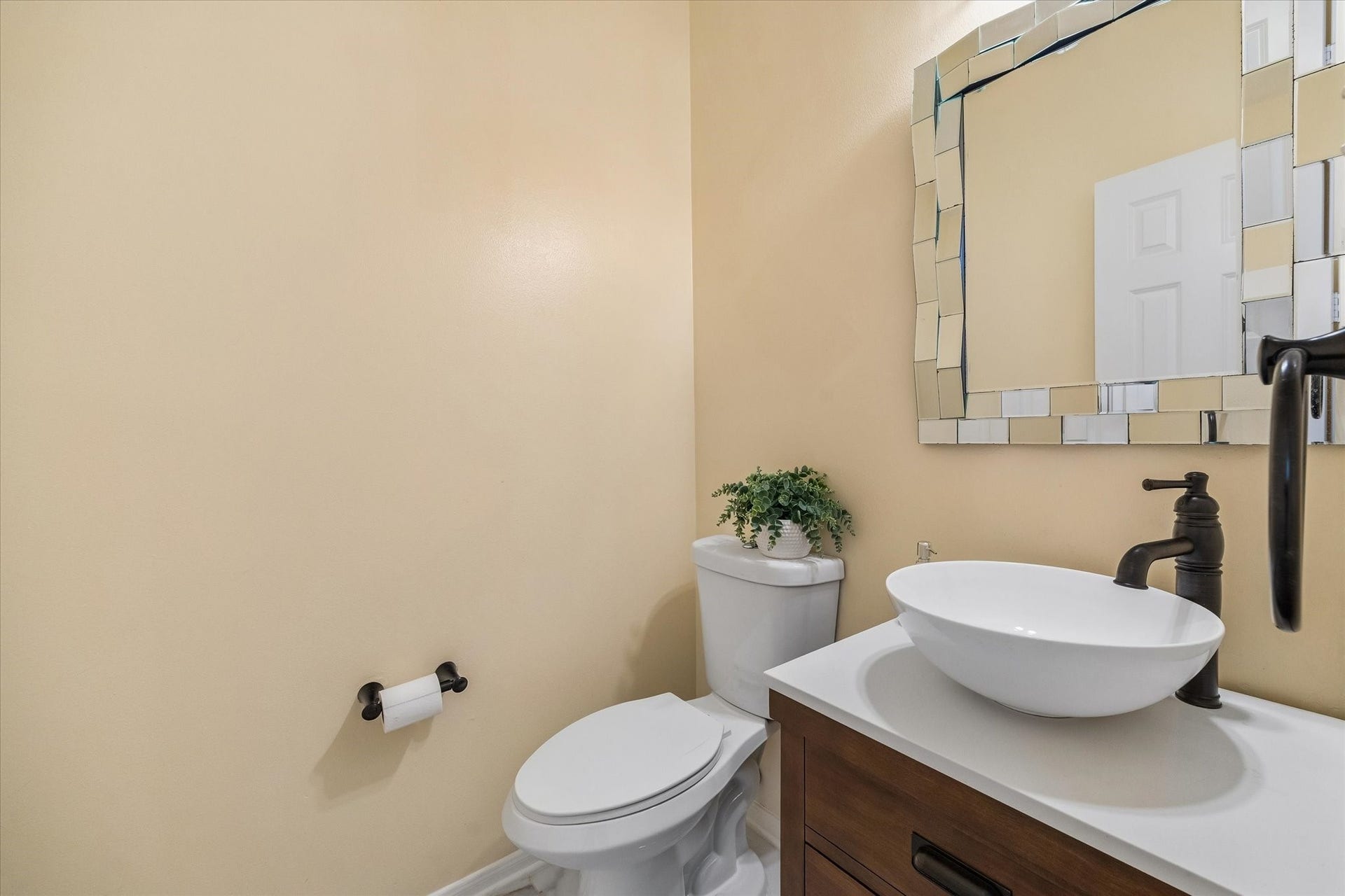 1115 Mulberry Lane, Bellaire, TX 77401 Chic powder room featuring a vessel sink with a modern faucet, elegant mirrored accents, and a warm, neutral color palette.