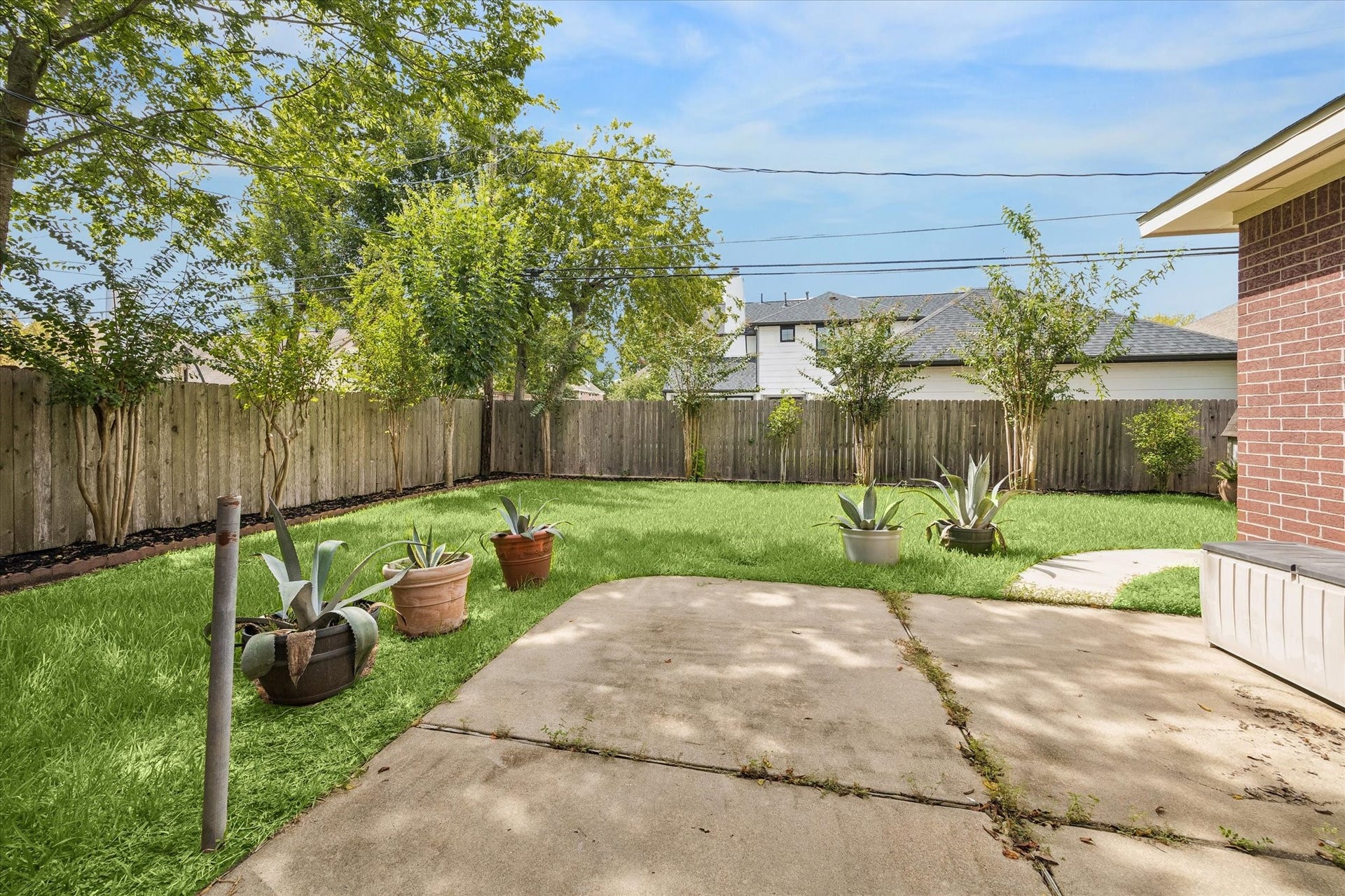 1115 Mulberry Lane, Bellaire, TX 77401 A charming backyard with a spacious patio and lush green lawn is perfect for outdoor relaxation and entertaining.