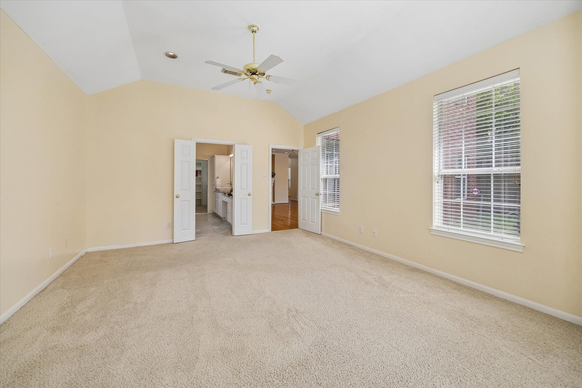 1115 Mulberry Lane, Bellaire, TX 77401 Spacious Primary bedroom, vaulted ceiling, double doors open to an ensuite bathroom, enhancing convenience and privacy.
